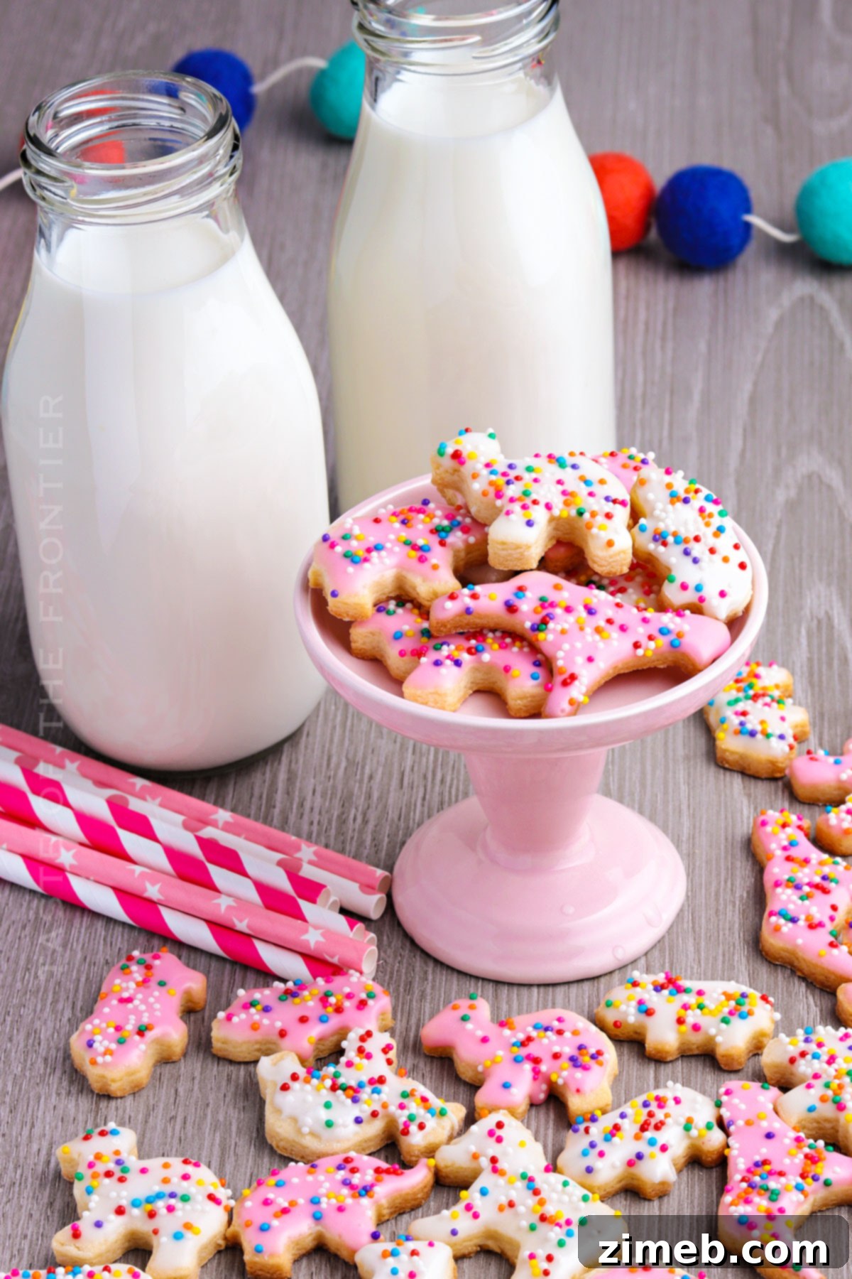 Whimsical Frosted Animal Treats 3 Frosted Animal Cookies with vibrant pink and white icing and rainbow nonpareils.