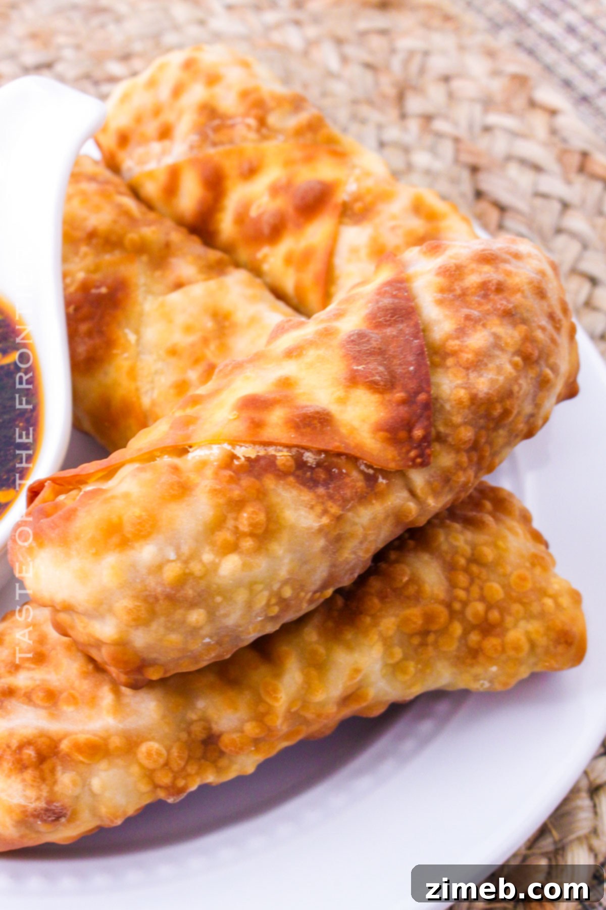 A close-up shot of a single crispy chicken egg roll, showing its golden-brown texture and appealing filling.
