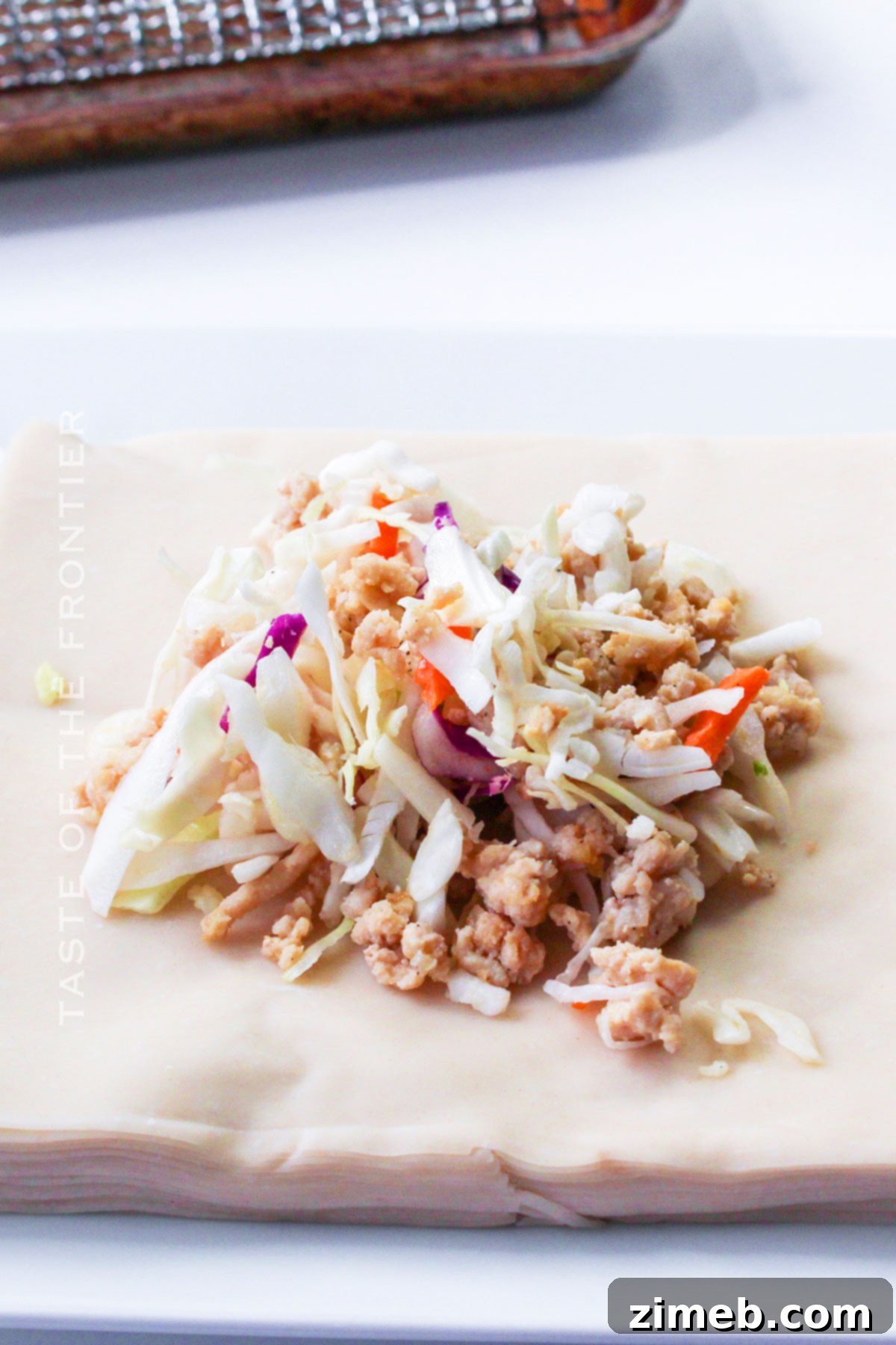 Detailed image showing how to properly roll an egg roll wrapper with filling before air frying, ensuring a tight seal.