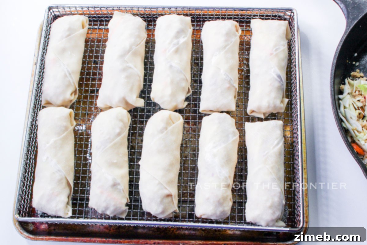 Air Fried Crispy Chicken Eggrolls, golden brown and ready to be served, resting in an air fryer basket.