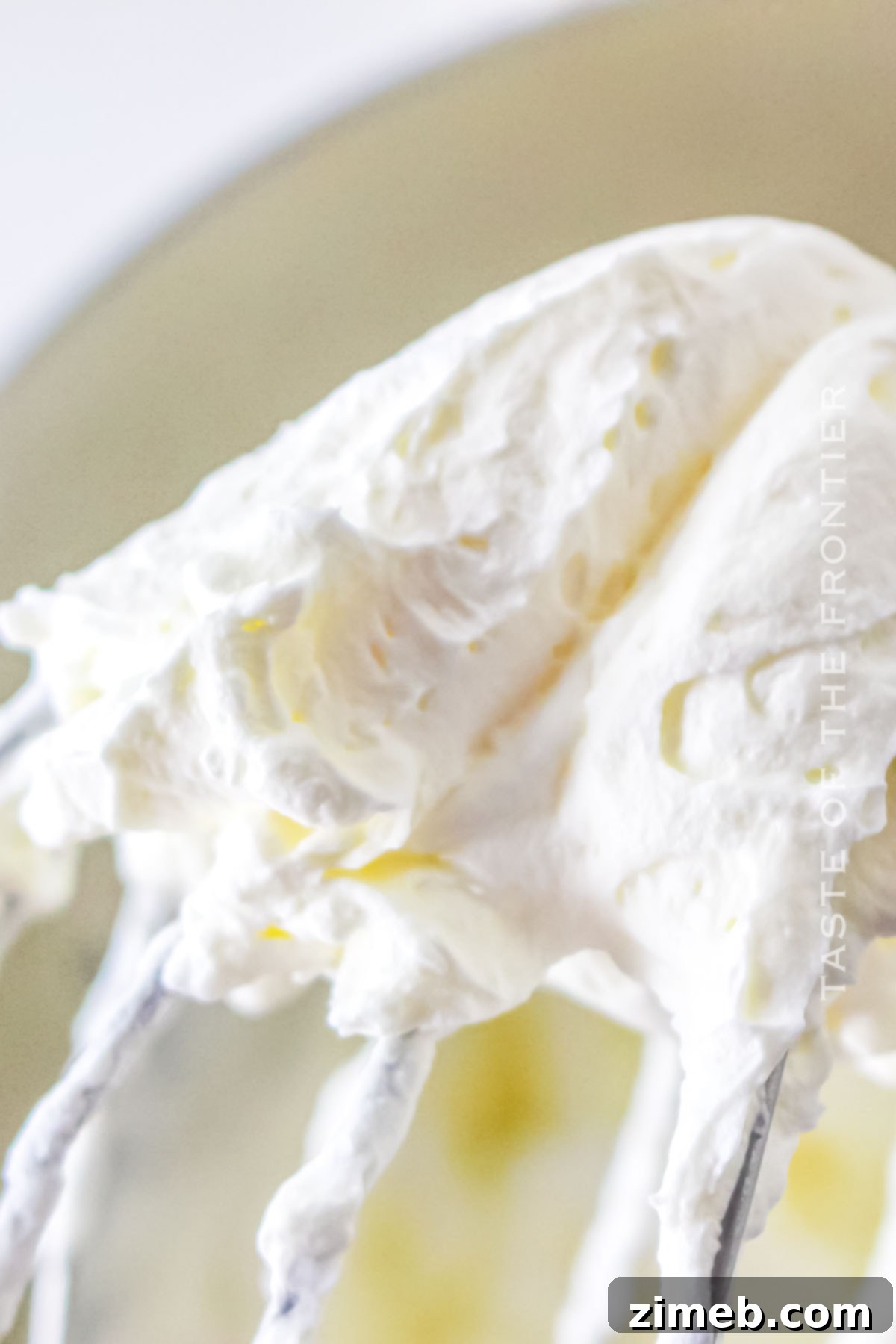 Fluffy whipped cream frosting spread evenly over a Tres Leches Cake.