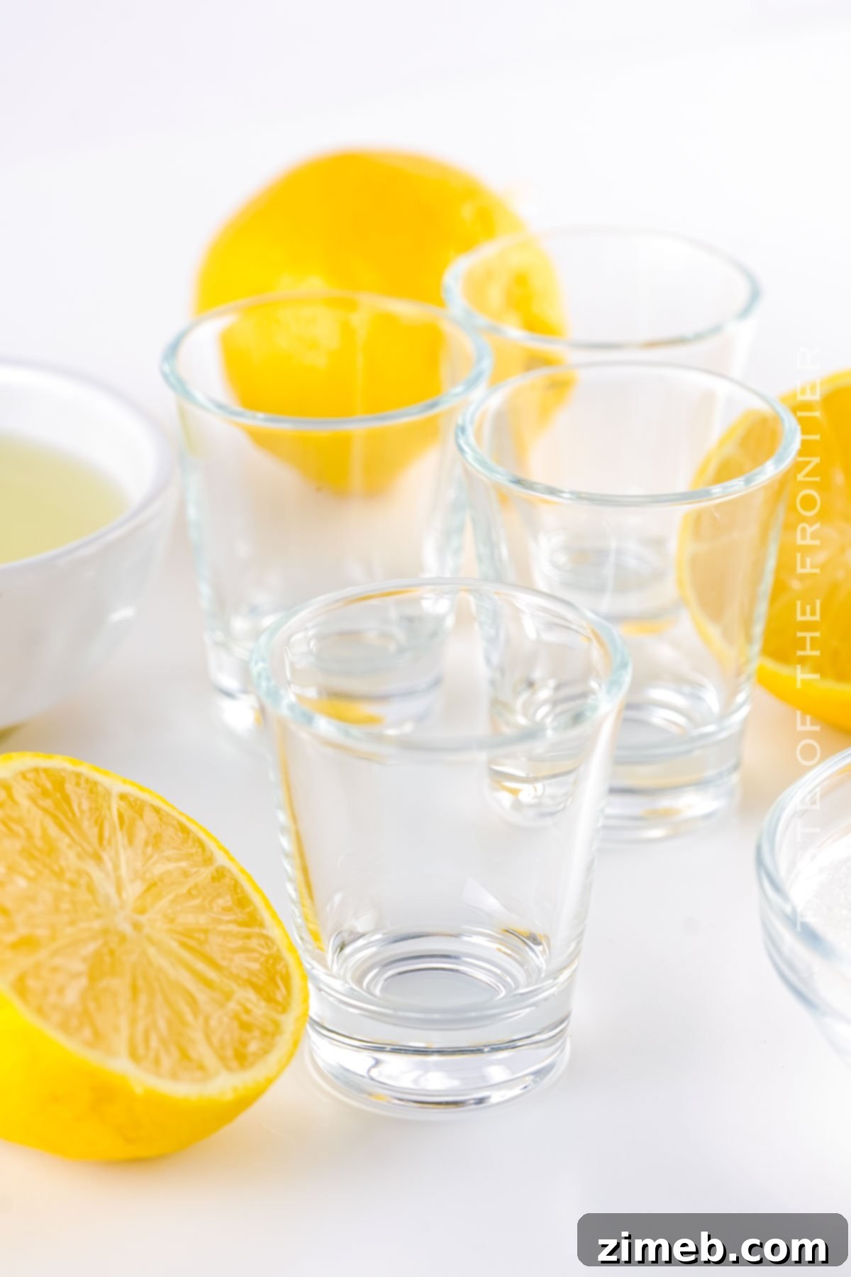 Several empty shot glasses lined up, waiting to be filled with the delicious Lemon Drop Shot mixture.