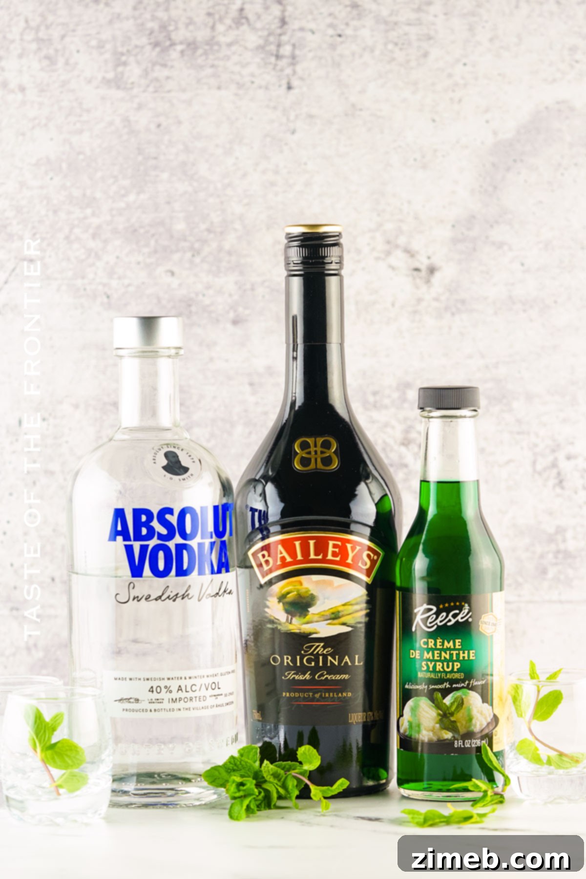 Midnight Thin Mint Shooters 4 All the ingredients for Dirty Girl Scout Shots laid out: a bottle of Bailey's Irish Cream, a bottle of vodka, and a bottle of creme de menthe.
