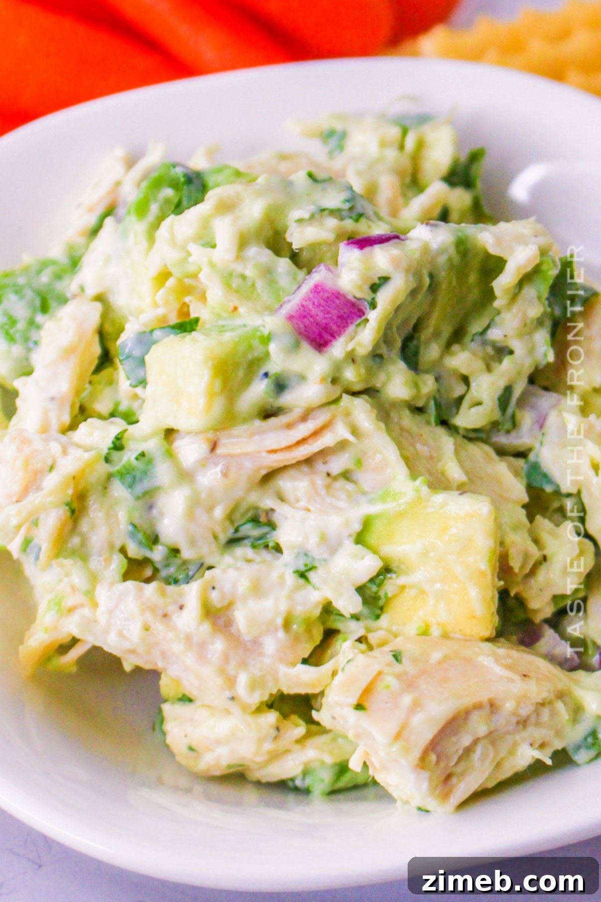 Easy Creamy Avocado Chicken Salad 2 Freshly made avocado chicken salad with visible chicken, avocado, red onion, and cilantro.