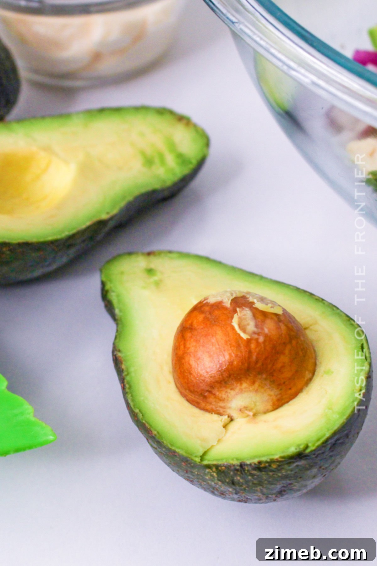 Easy Creamy Avocado Chicken Salad 6 Sliced avocado halves with pits removed, ready for cubing.