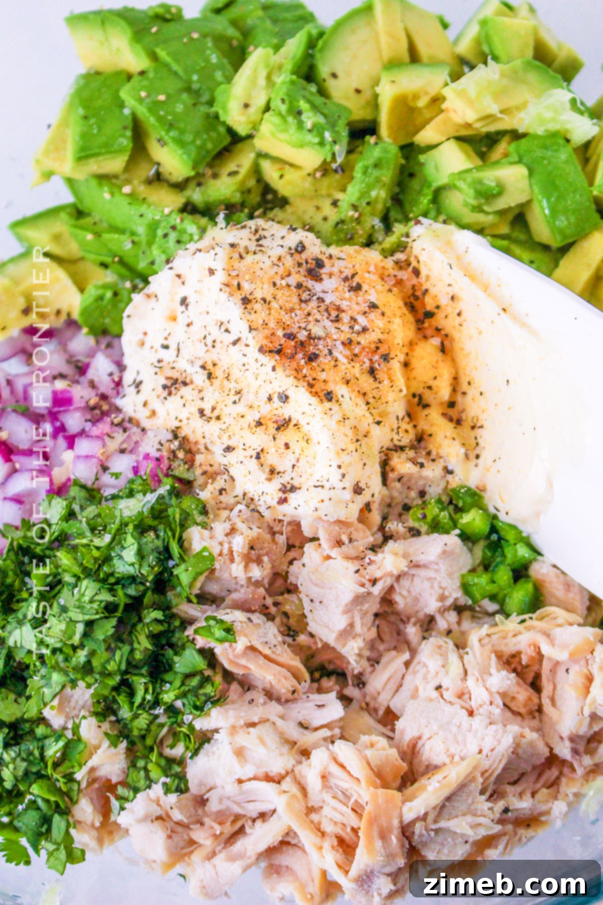 Easy Creamy Avocado Chicken Salad 8 Step-by-step image showing how to mix ingredients for Avocado Chicken Salad in a bowl.