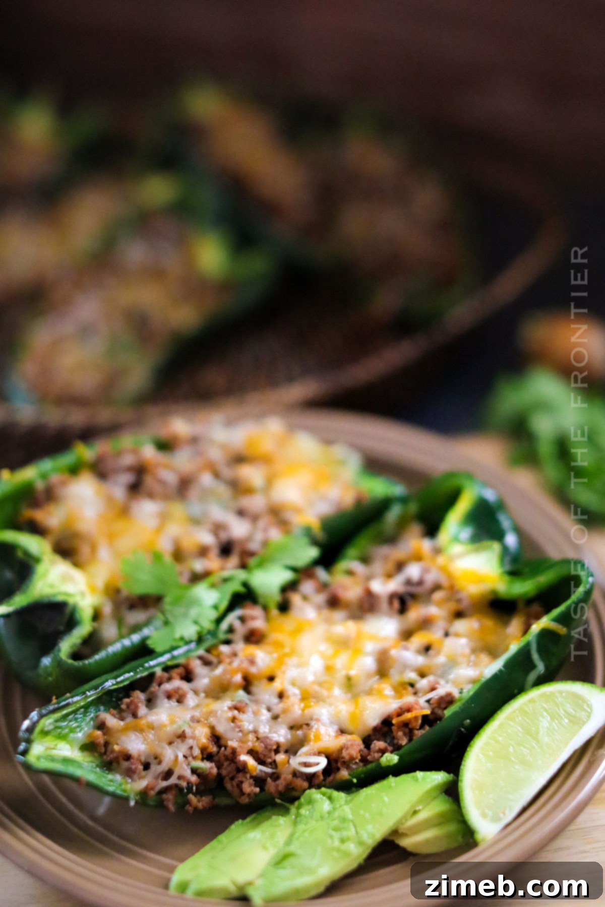 Two stuffed poblano peppers garnished with cilantro