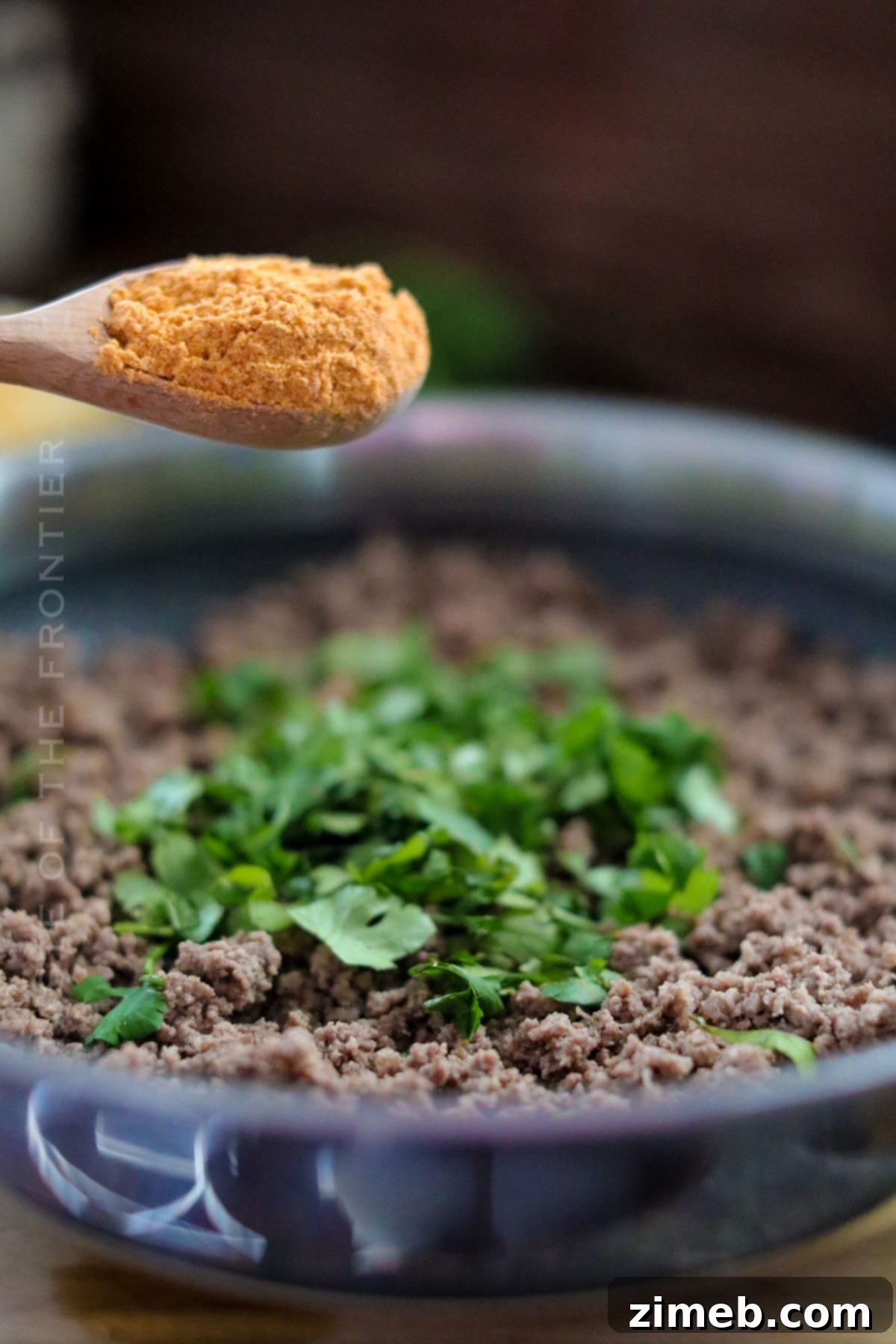 Adding seasoning to ground beef filling for poblano peppers