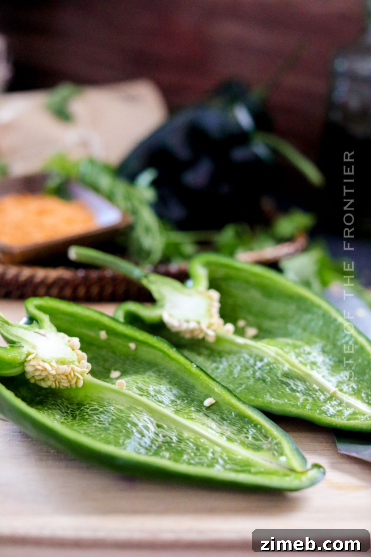 Preparing poblano peppers for stuffing by halving them