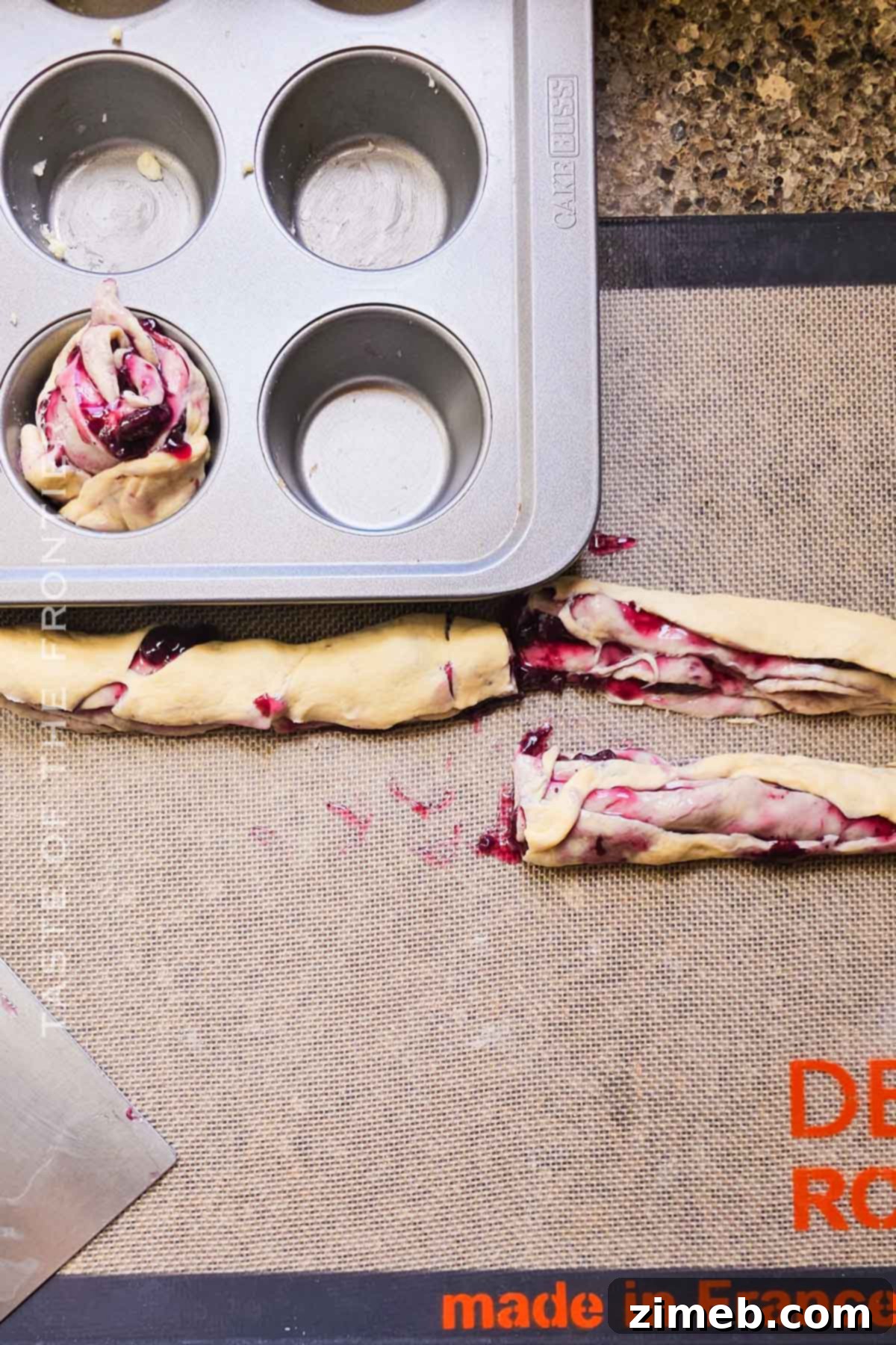 Blueberry Bliss Cruffins 7 Cutting the filled crescent roll dough logs for blueberry cruffins.