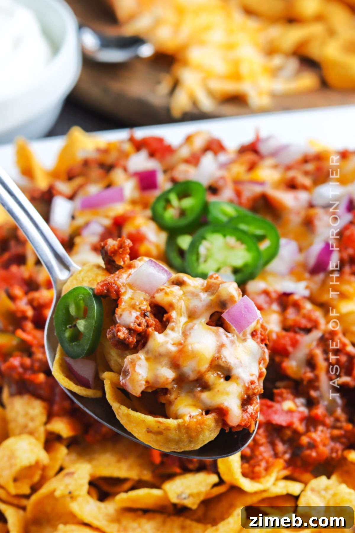 Chili Chip Comfort Bowl 3 Close-up of cheesy chips with hearty chili, ready to serve as a Frito Chili Pie