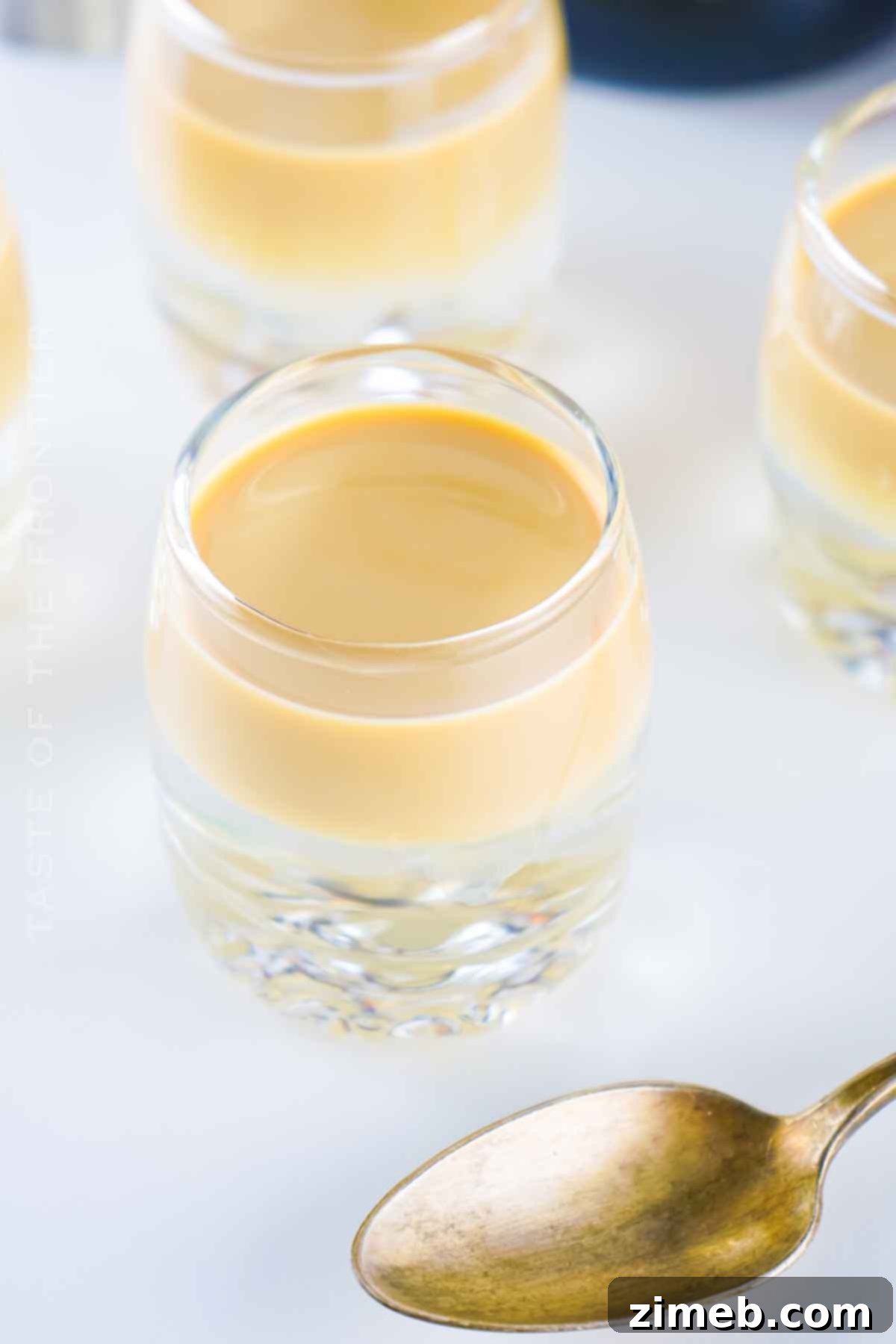 A glass of butterscotch drink with layers and whipped cream