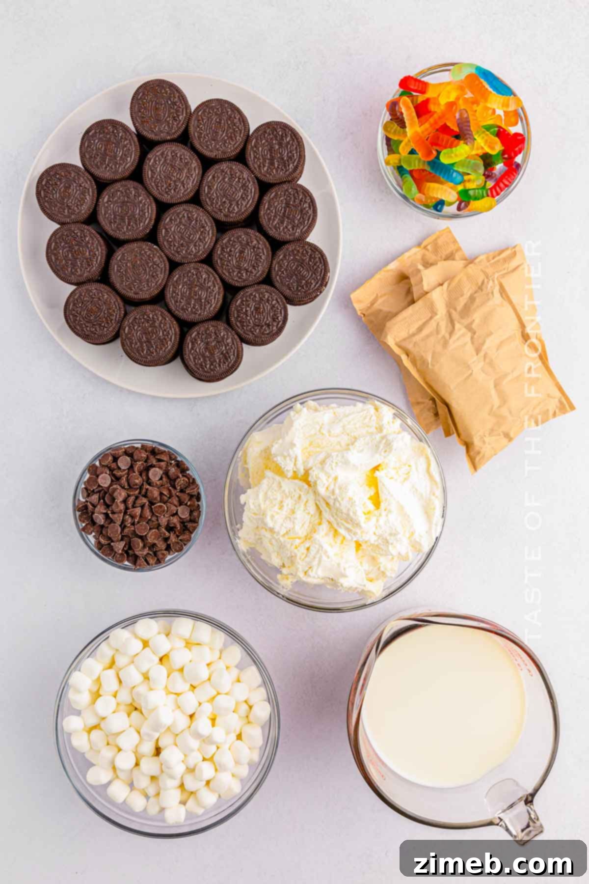 Dreamy Oreo Fluff 4 Oreo Fluff ingredients displayed on a counter: Oreo cookies, pudding mix, milk, Cool Whip, marshmallows, and chocolate chips.