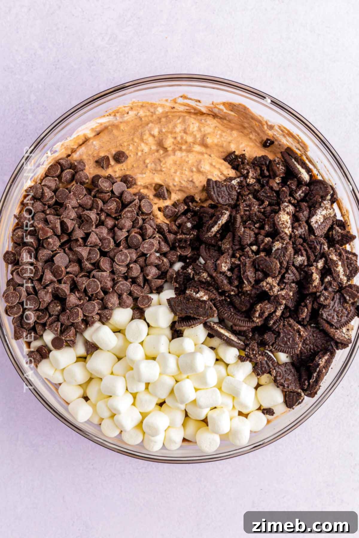 Dreamy Oreo Fluff 5 Hands mixing ingredients in a bowl to make Oreo Fluff.