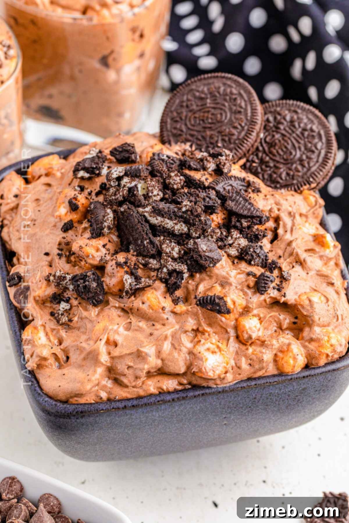 Dreamy Oreo Fluff 7 Oreo Fluff in a clear glass dish, topped with more crushed Oreos and gummy worms, creating a 'dirt fluff' look.