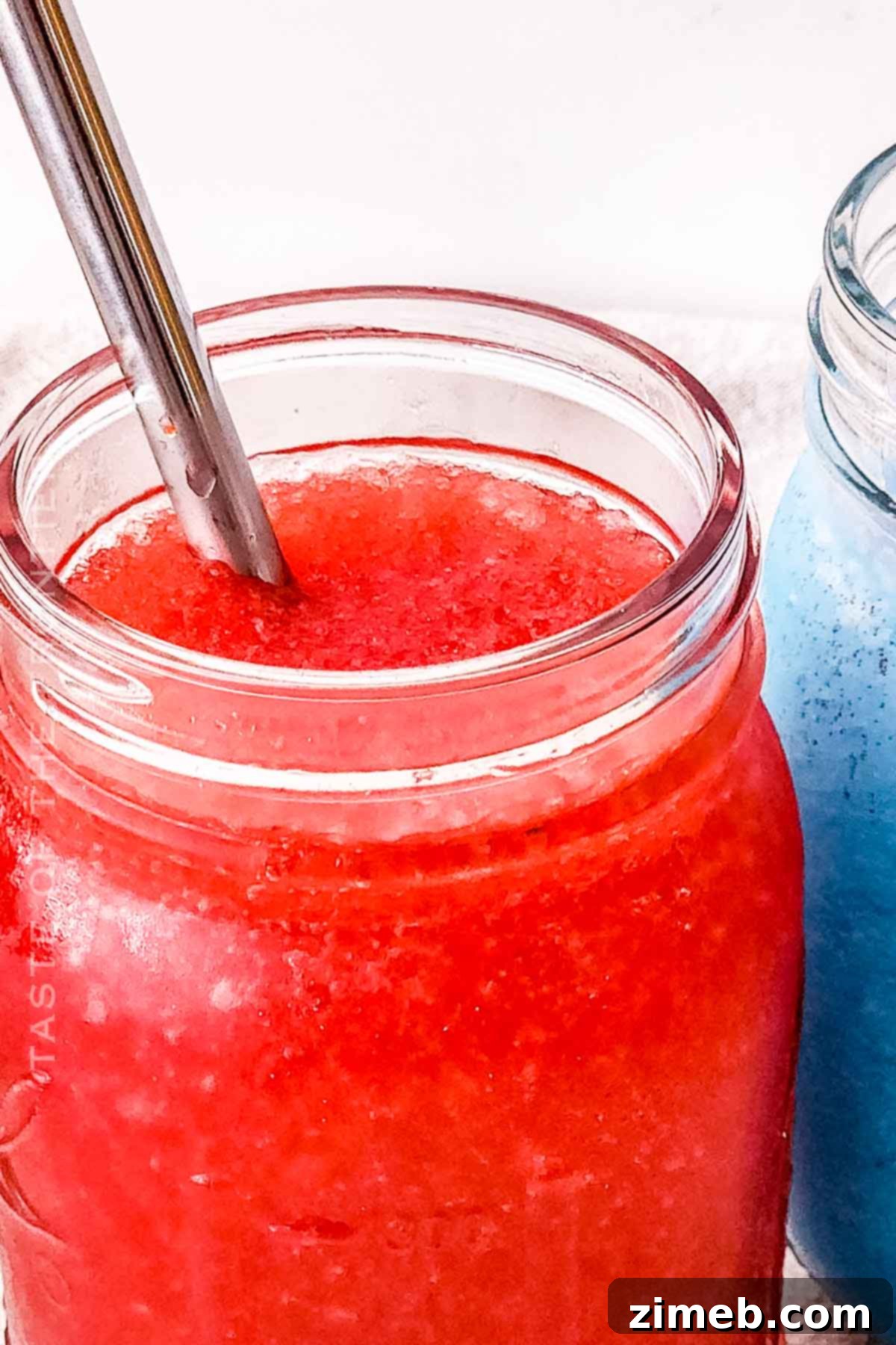 Whip Up Your Own Refreshing Kool-Aid Slushie 2 How to Make a Kool-Aid Slushie - a vibrant red slushie in a glass with a straw