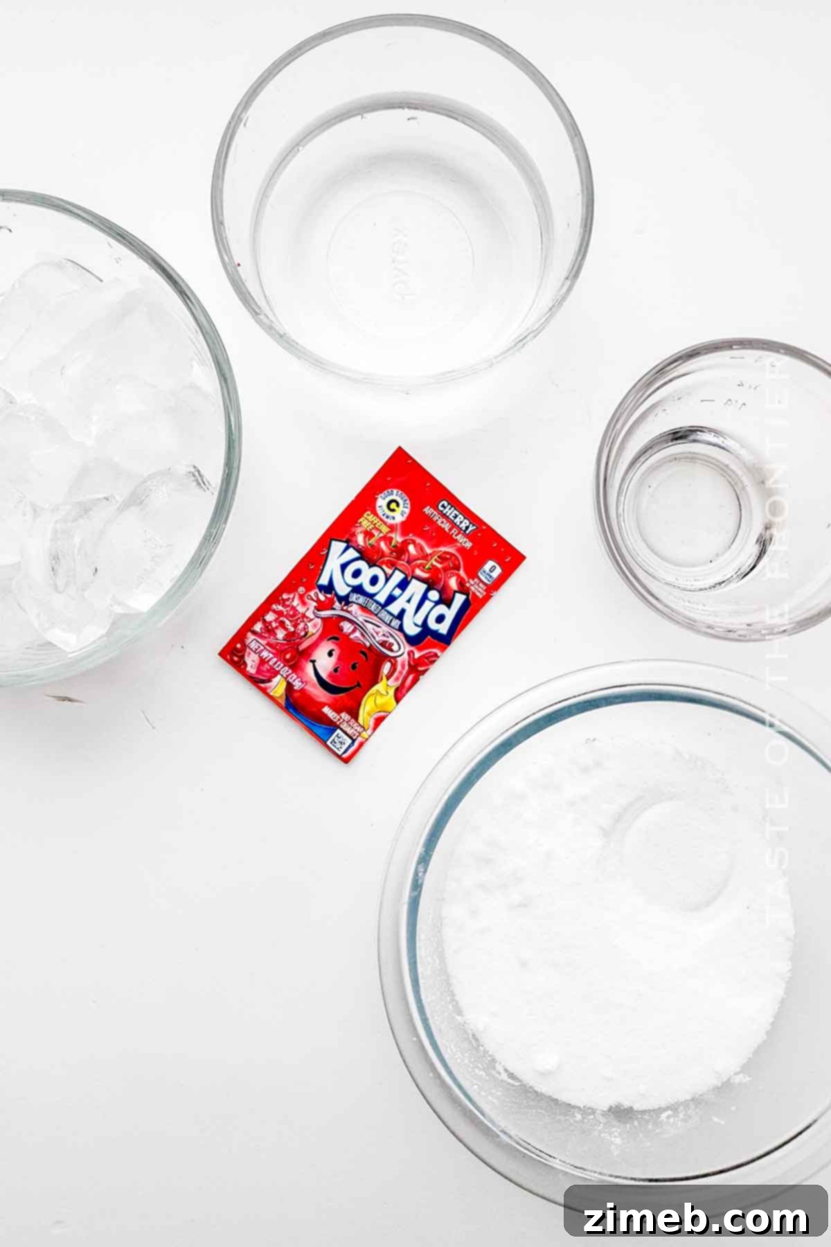 Whip Up Your Own Refreshing Kool-Aid Slushie 4 Kool-Aid Slushie ingredients laid out on a table