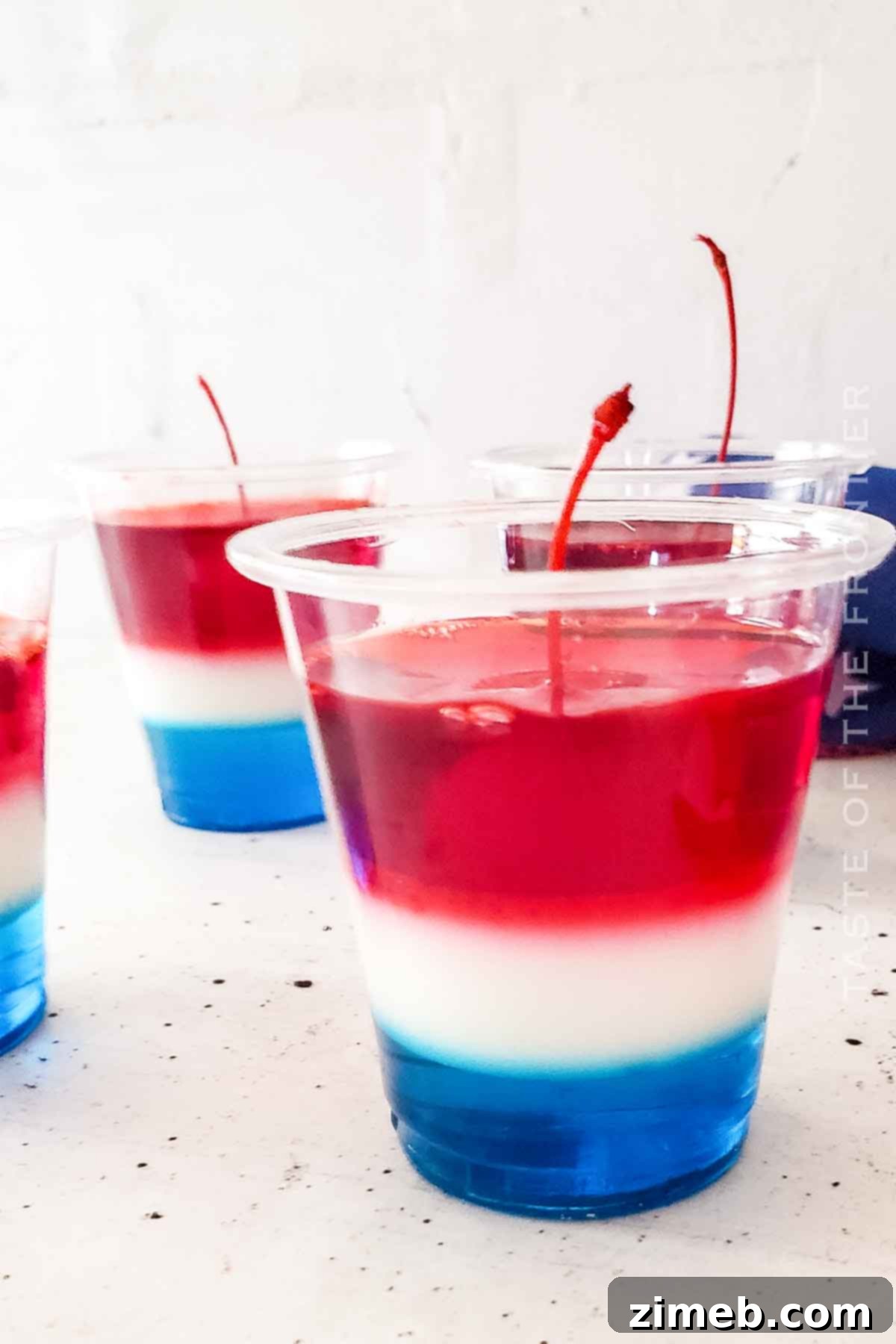 A festive patriotic jello treat, showcasing the perfect red, white, and blue layers of a Bomb Pop Jello Shot.