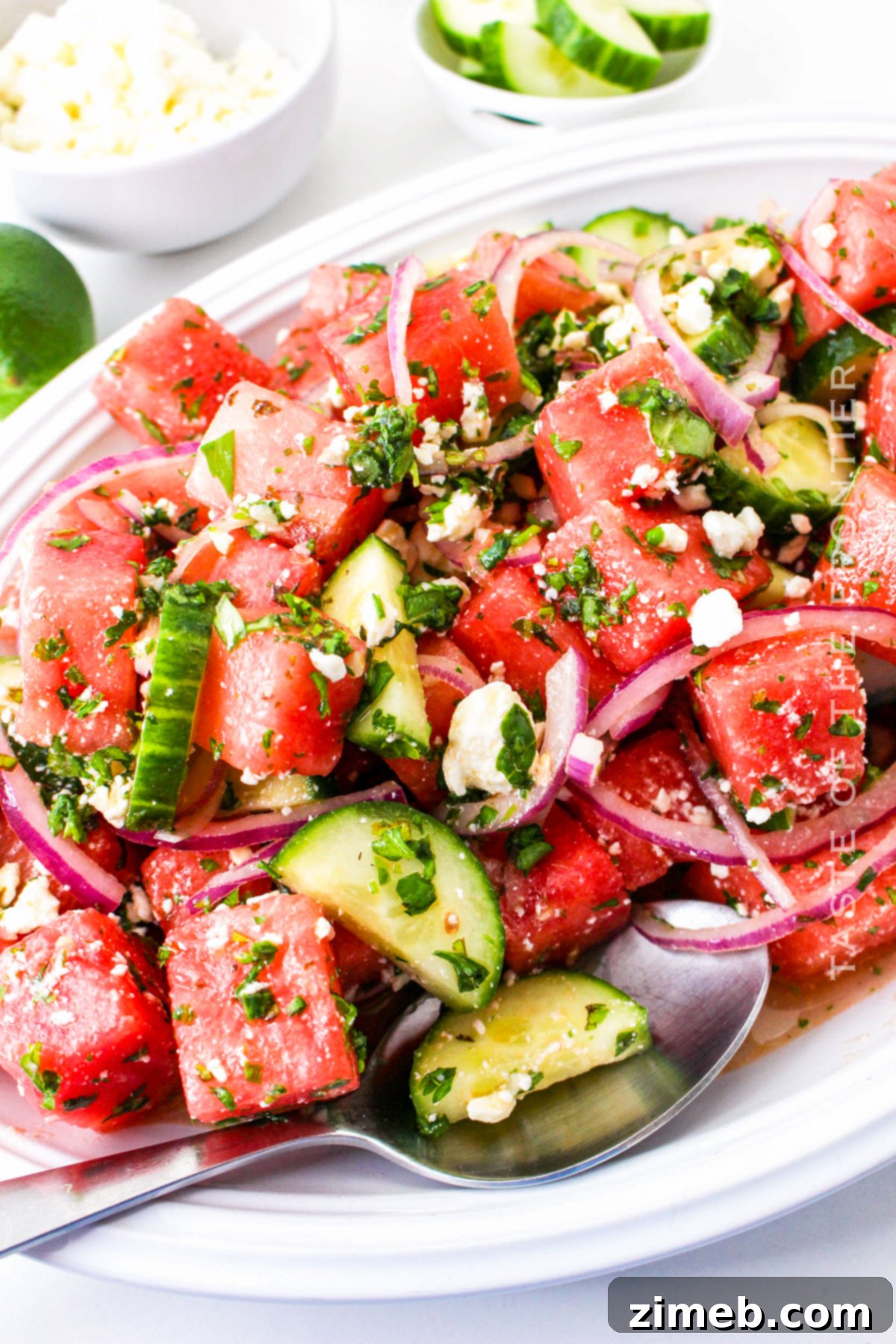 A vibrant side dish featuring summer melon, goat cheese, and fresh herbs.