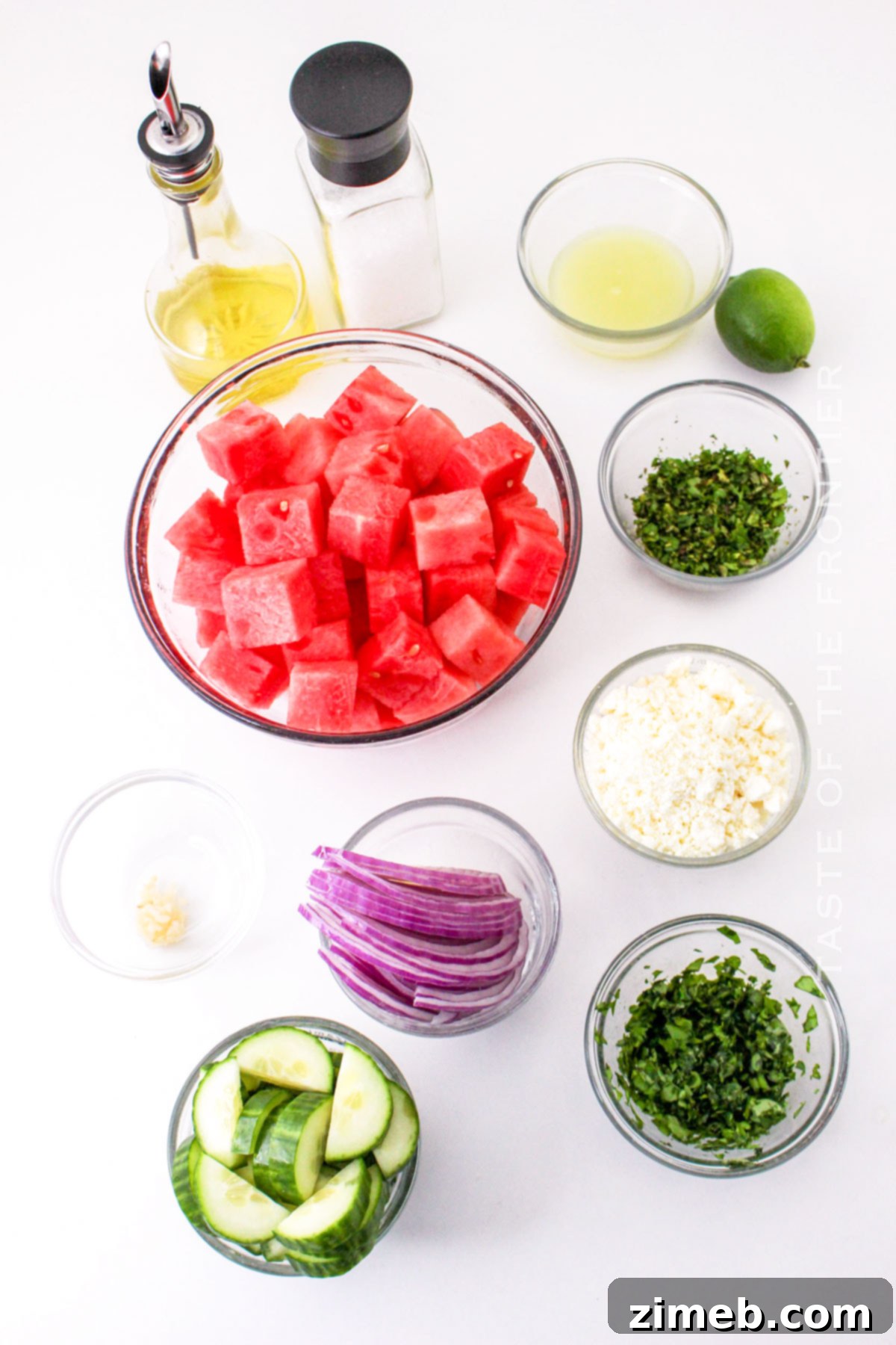 Fresh ingredients for Watermelon Salad with Goat Cheese laid out on a cutting board.