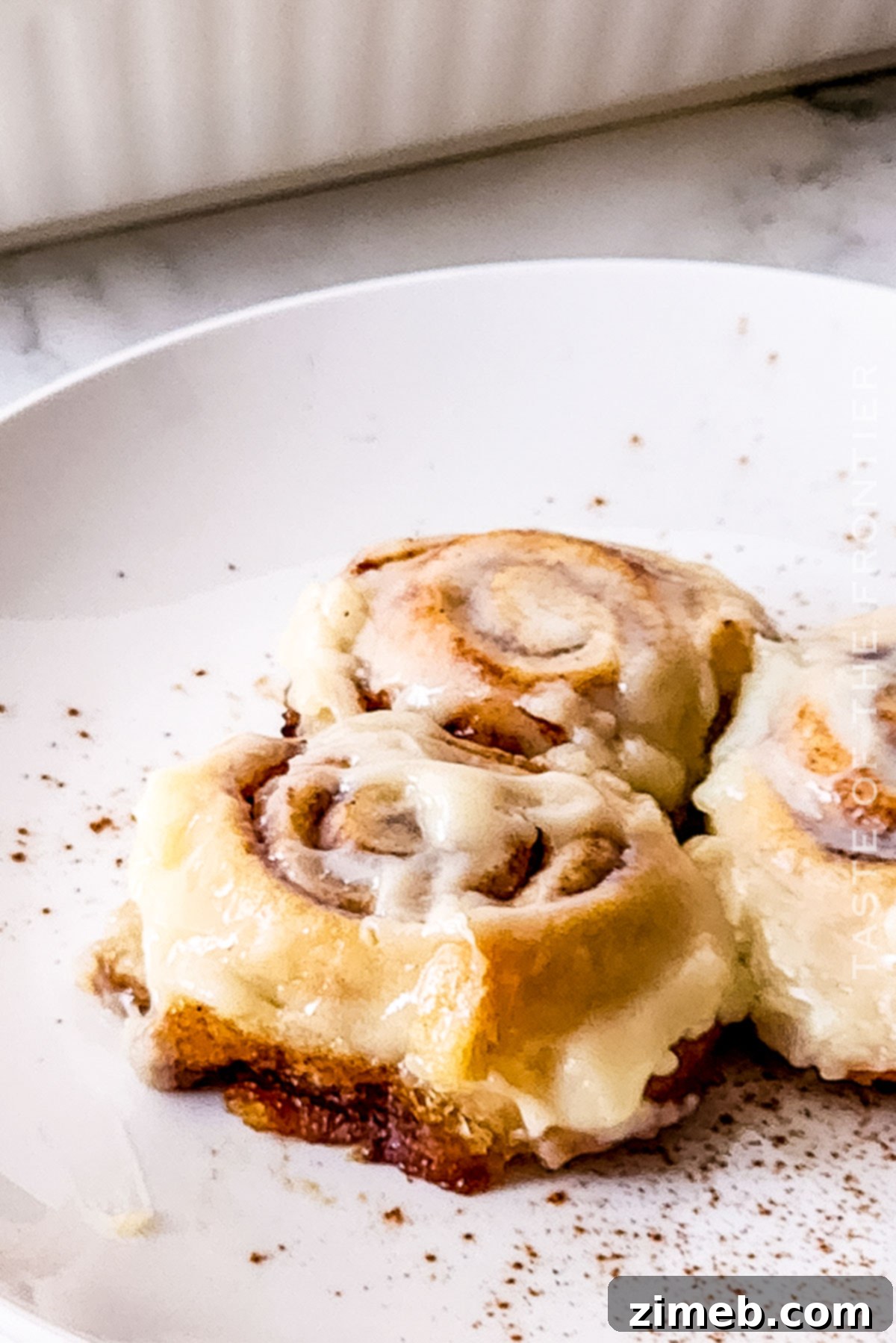 An array of easy cinnamon roll recipe on a plate, garnished with frosting, ready for a delicious breakfast.