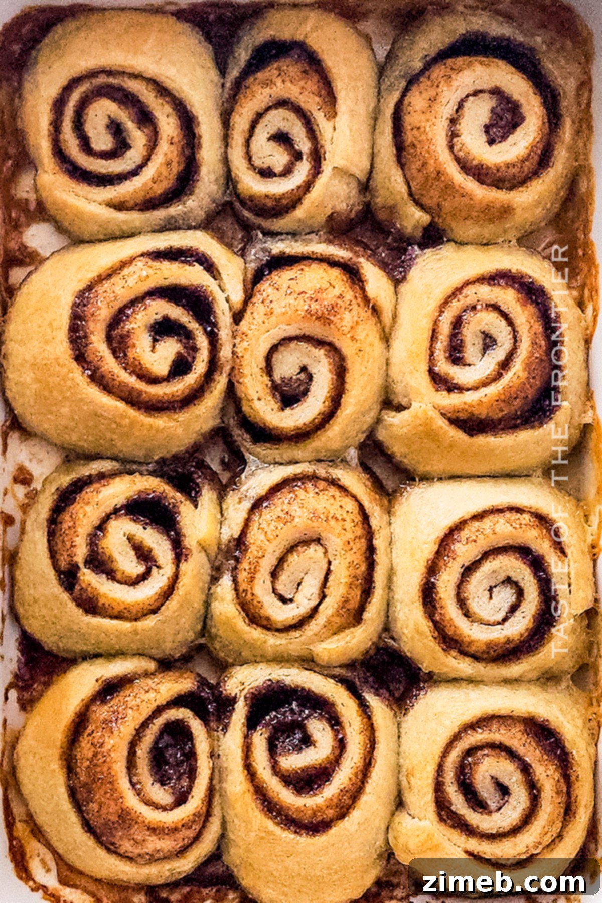 Plate of baked mini cinnamon rolls, fresh from the oven and glistening with frosting.