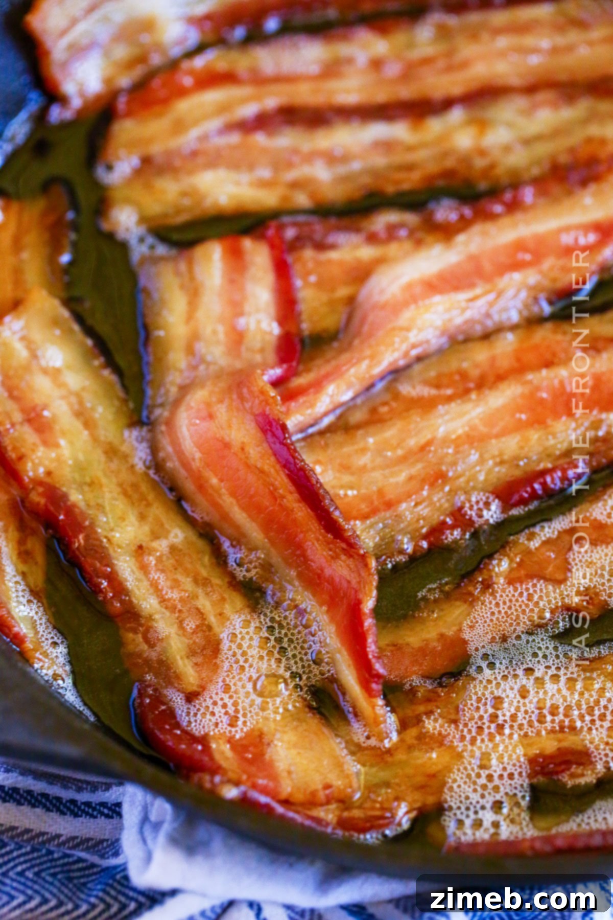 Gourmet Smoked Bacon 2 Crispy Smoked Bacon slices perfectly cooked in a cast iron skillet, ready to be enjoyed.