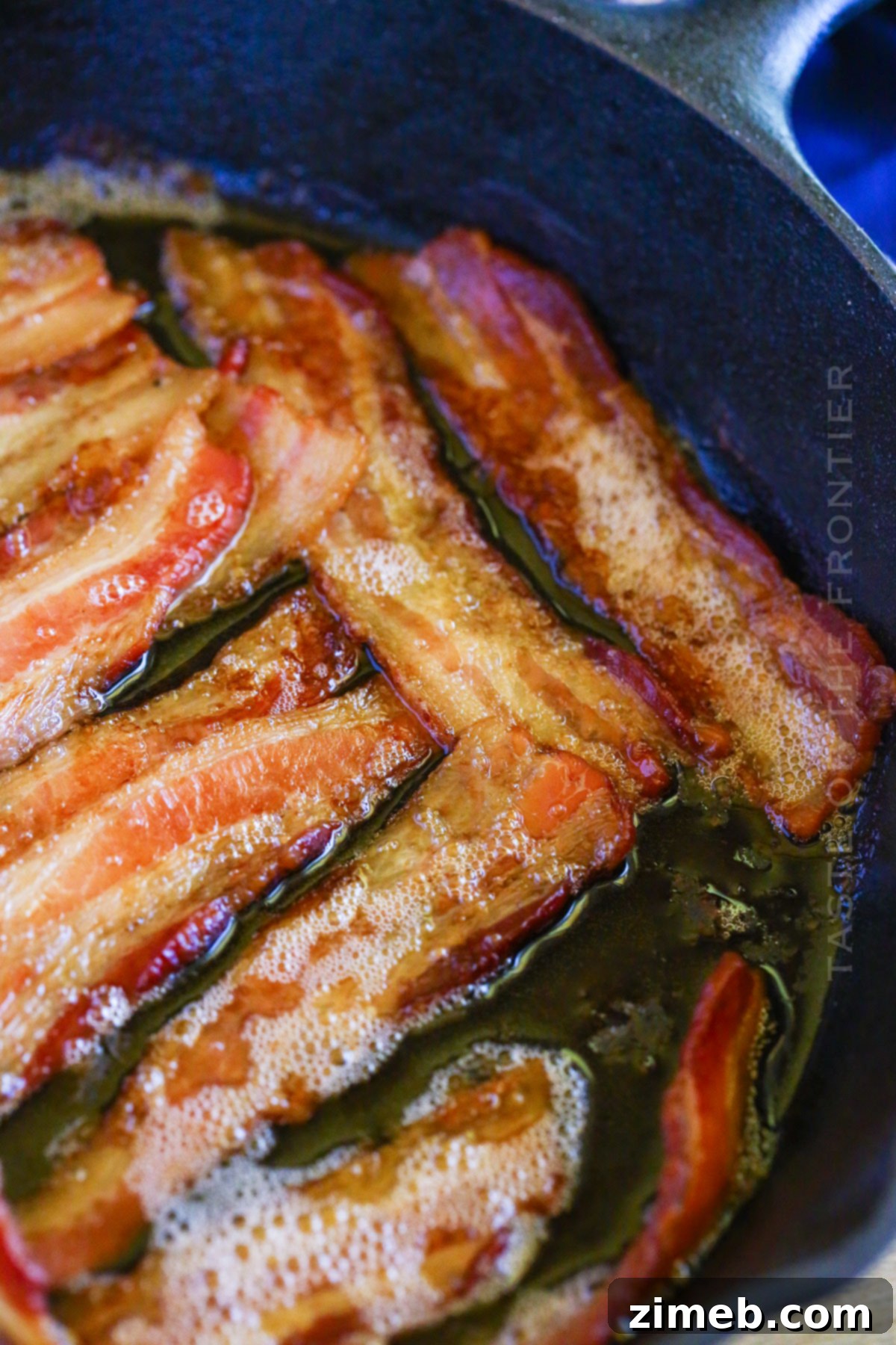 Gourmet Smoked Bacon 15 A serving of Smoked Bacon on a wooden board with a skillet in the background, ready for enjoying.