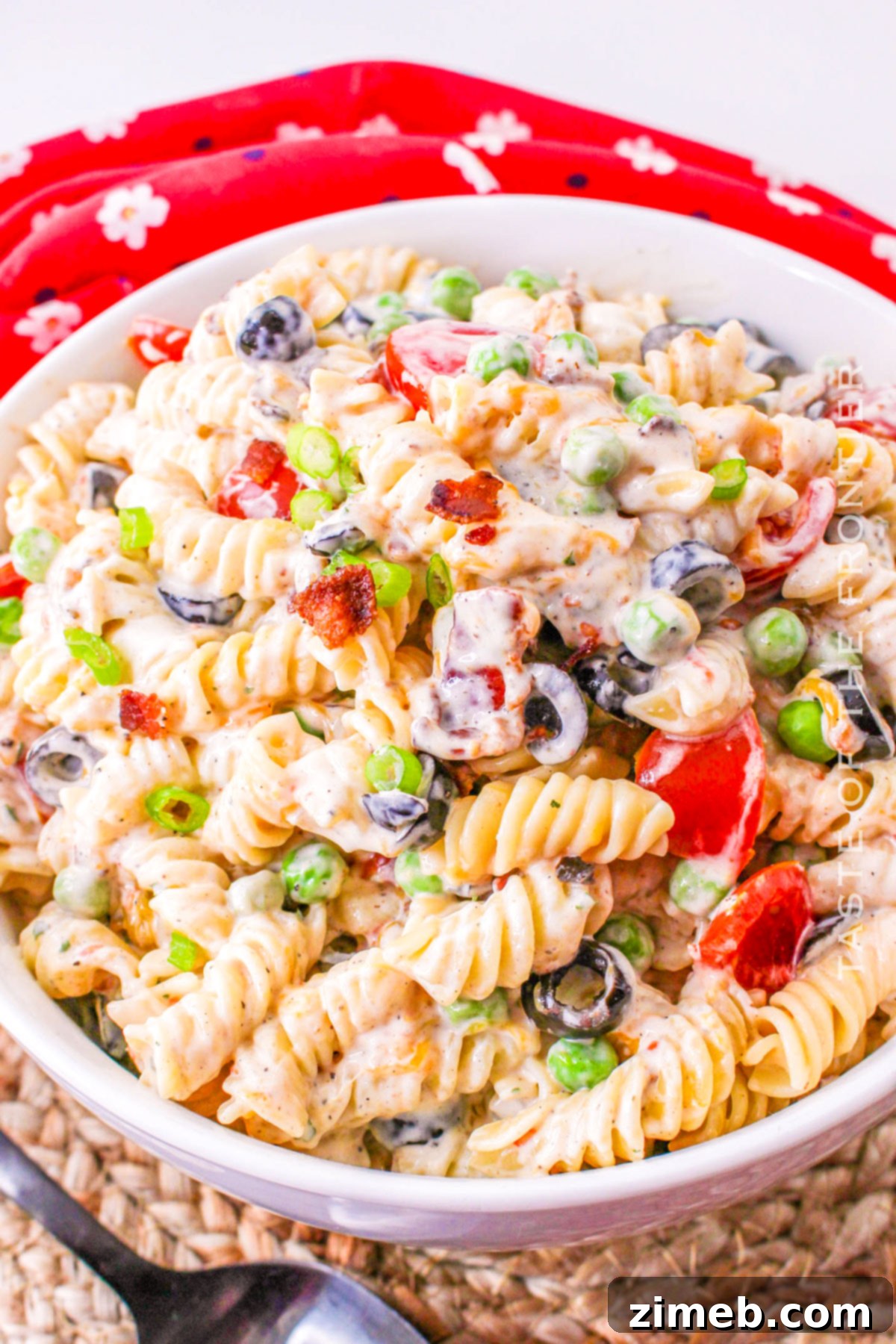 Close-up of a bowl of creamy bacon ranch pasta salad, highlighting the fresh ingredients and rich texture.