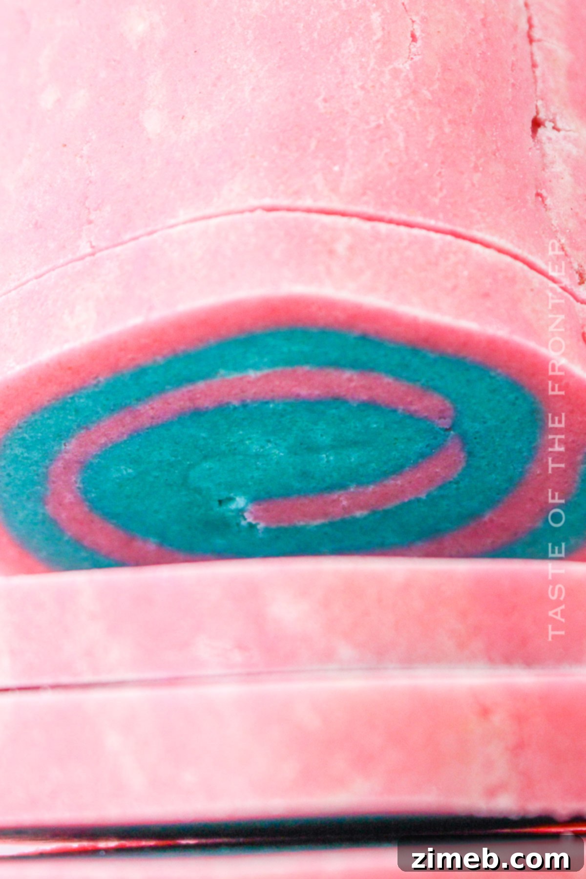 Rolled and layered pink and blue cookie dough for pinwheel cookies