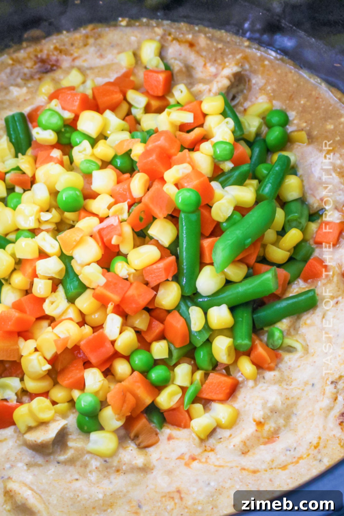Creamy Slow Cooker Chicken Pasta 5 Adding frozen mixed vegetables to the slow cooker chicken pasta