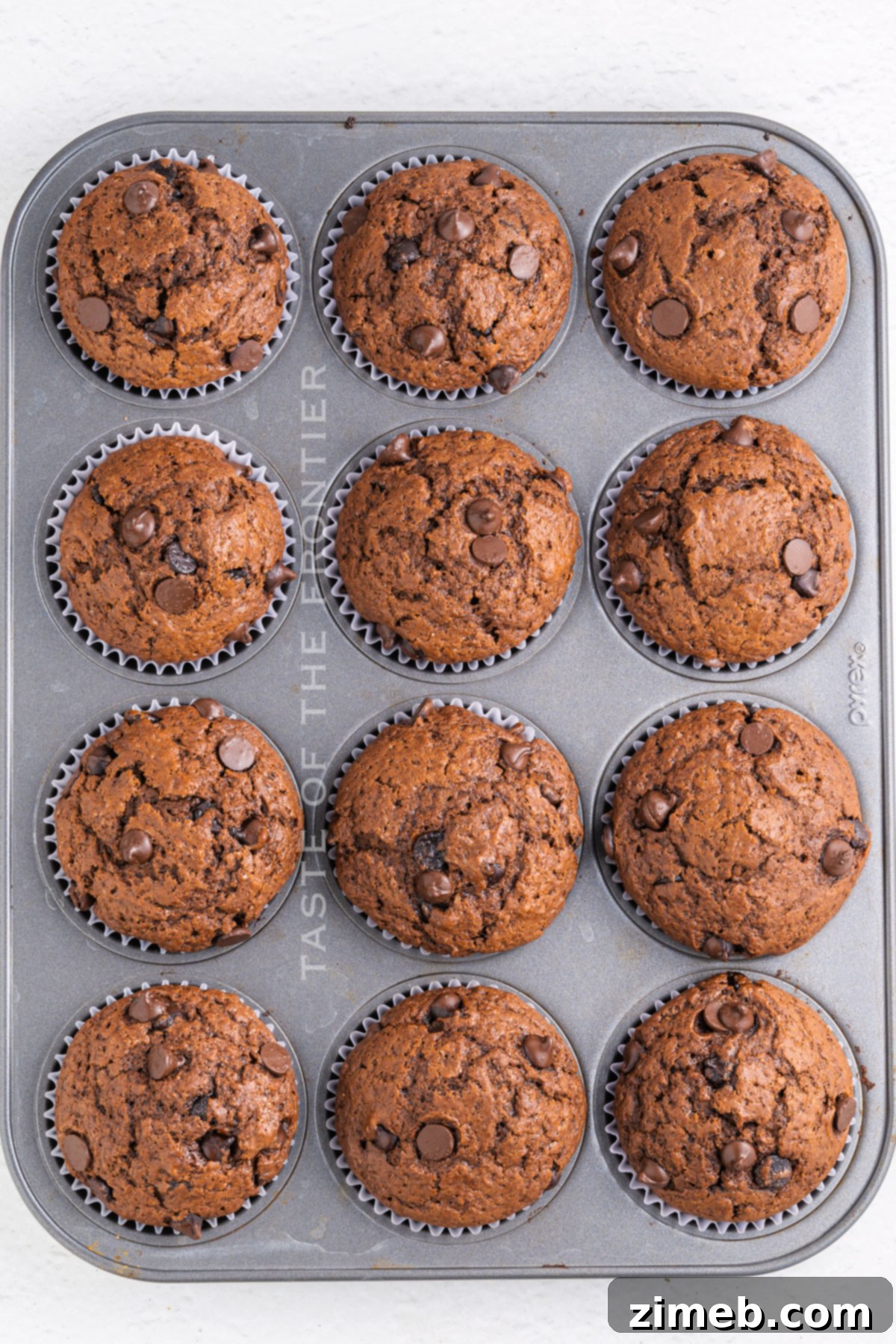 Freshly baked chocolate muffins with a topping of melted chocolate.