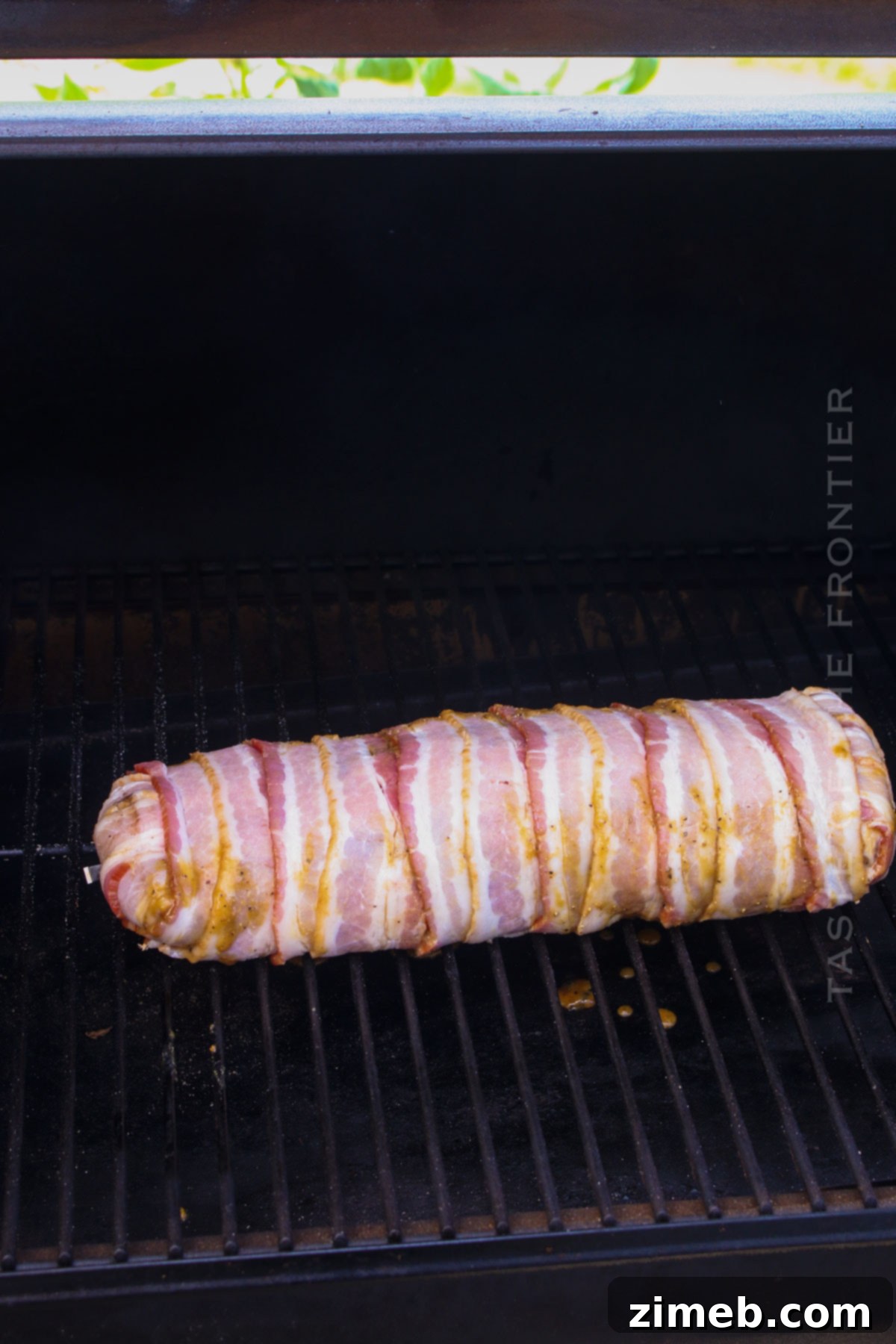 Tender Smoked Pork Loin 6 Bacon-wrapped pork loin on a smoker grill