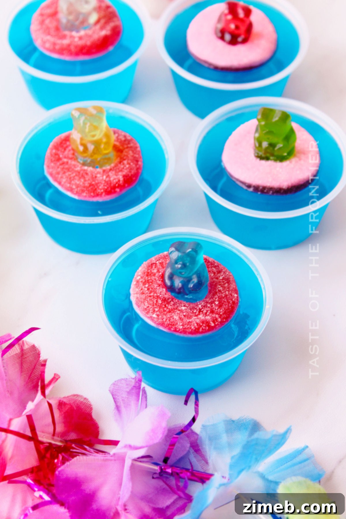 Close-up of three Pool Party Jello Shots with gummy bear toppings for adults.