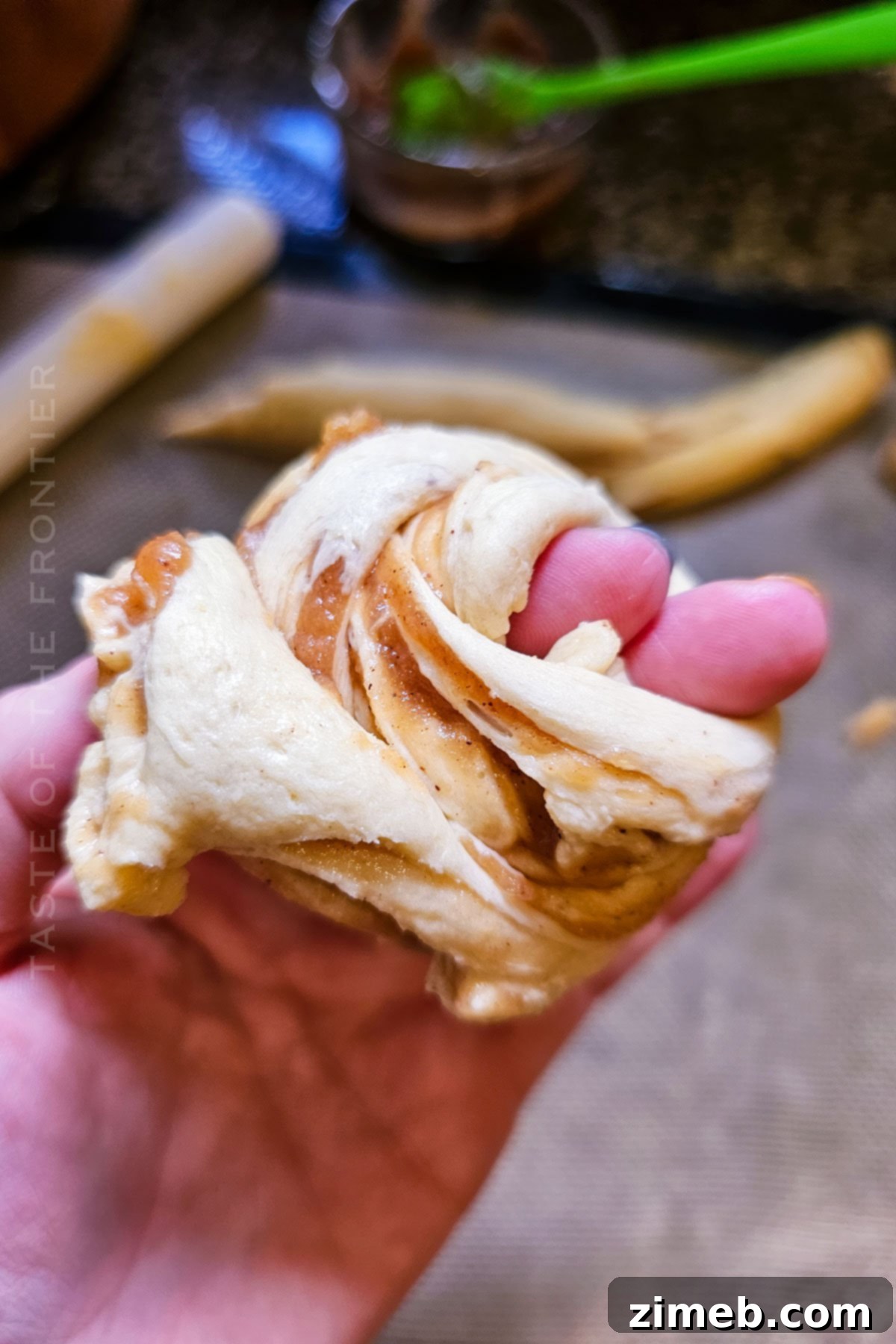 Wrapping crescent roll dough around fingers to shape cruffins