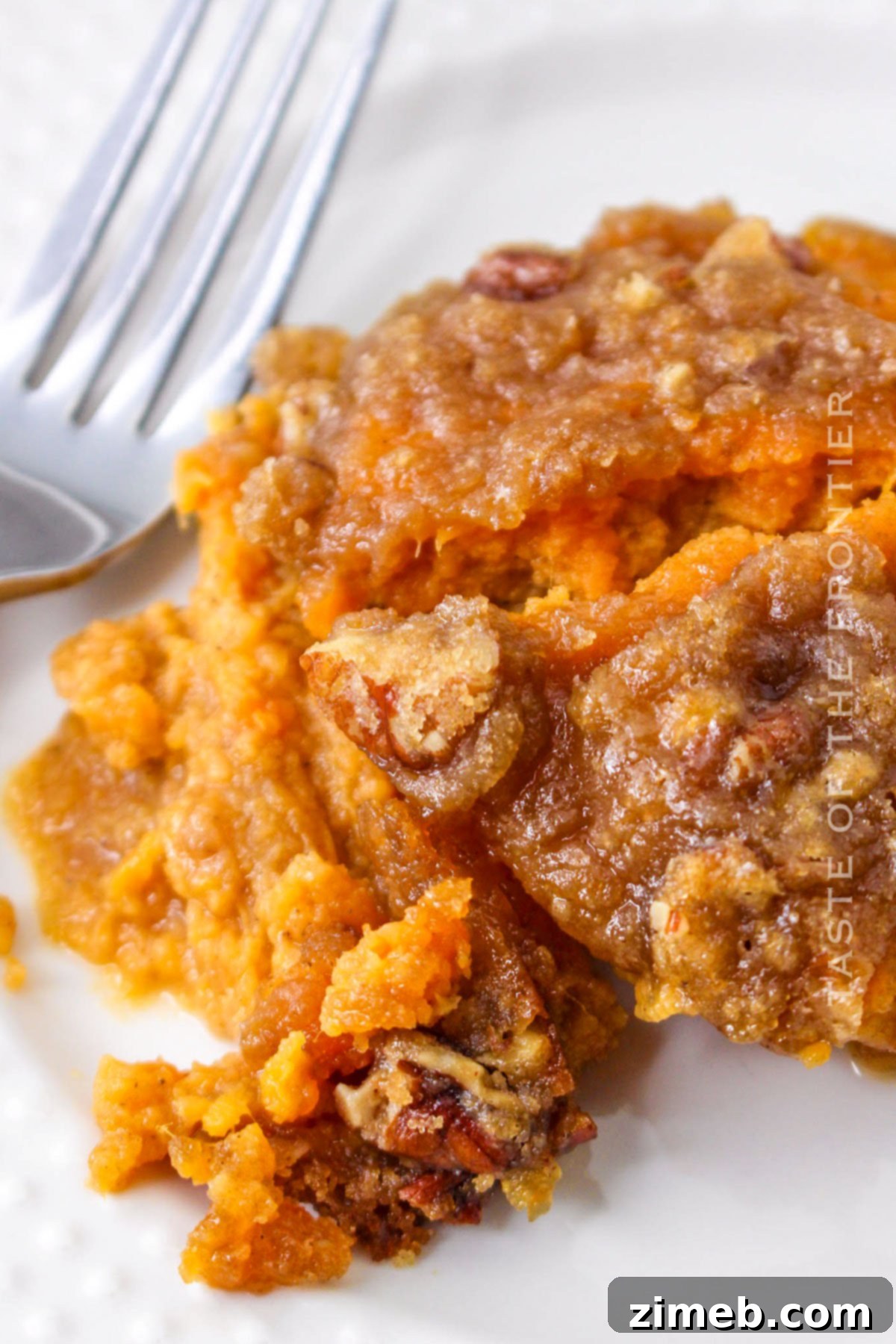 Creamy sweet potatoes topped with pecan streusel, ready to be baked as a holiday side dish