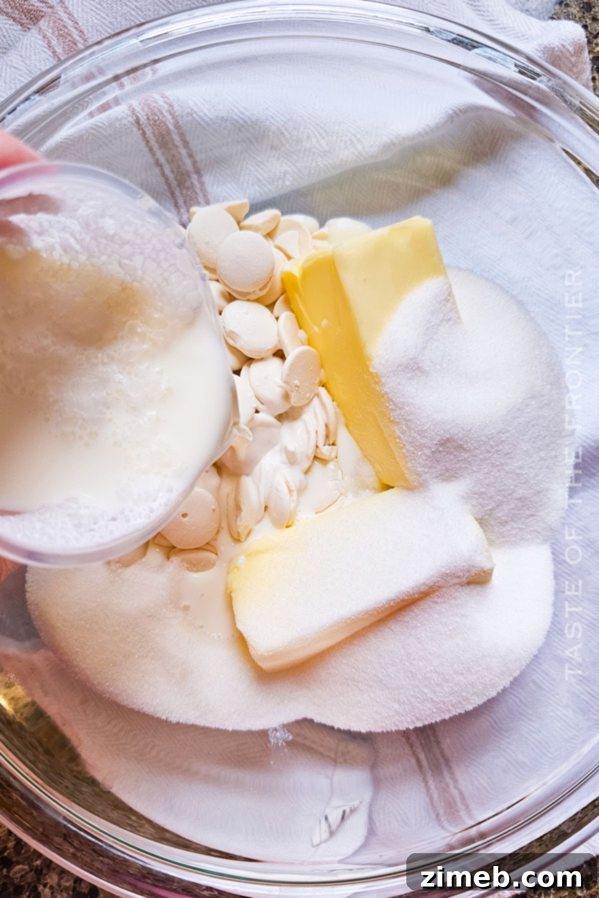 White chocolate pieces melting in a double boiler, a crucial step for the mud cake recipe.