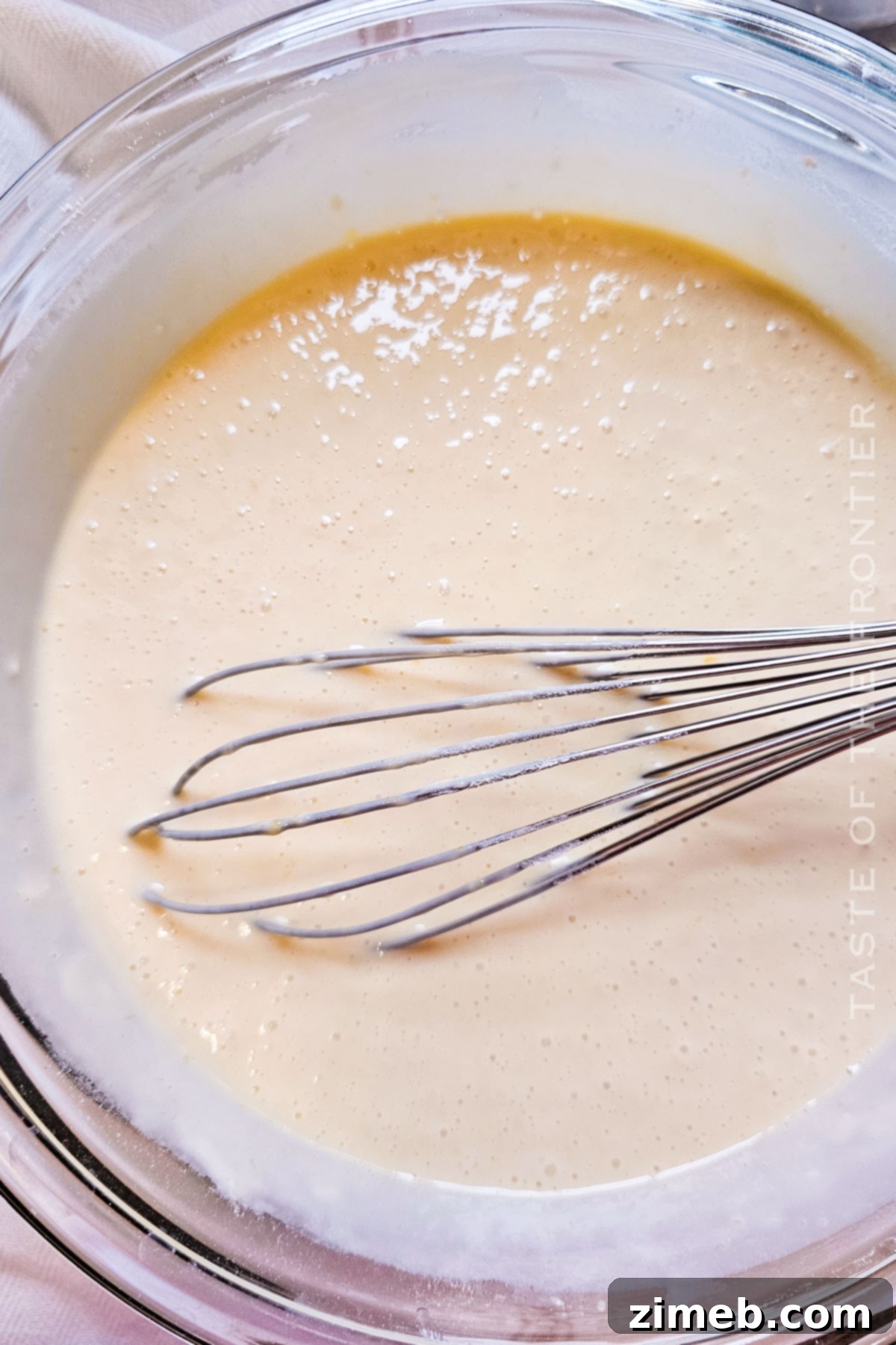 Smooth and creamy White Chocolate Cake batter in a large mixing bowl, ready for baking.