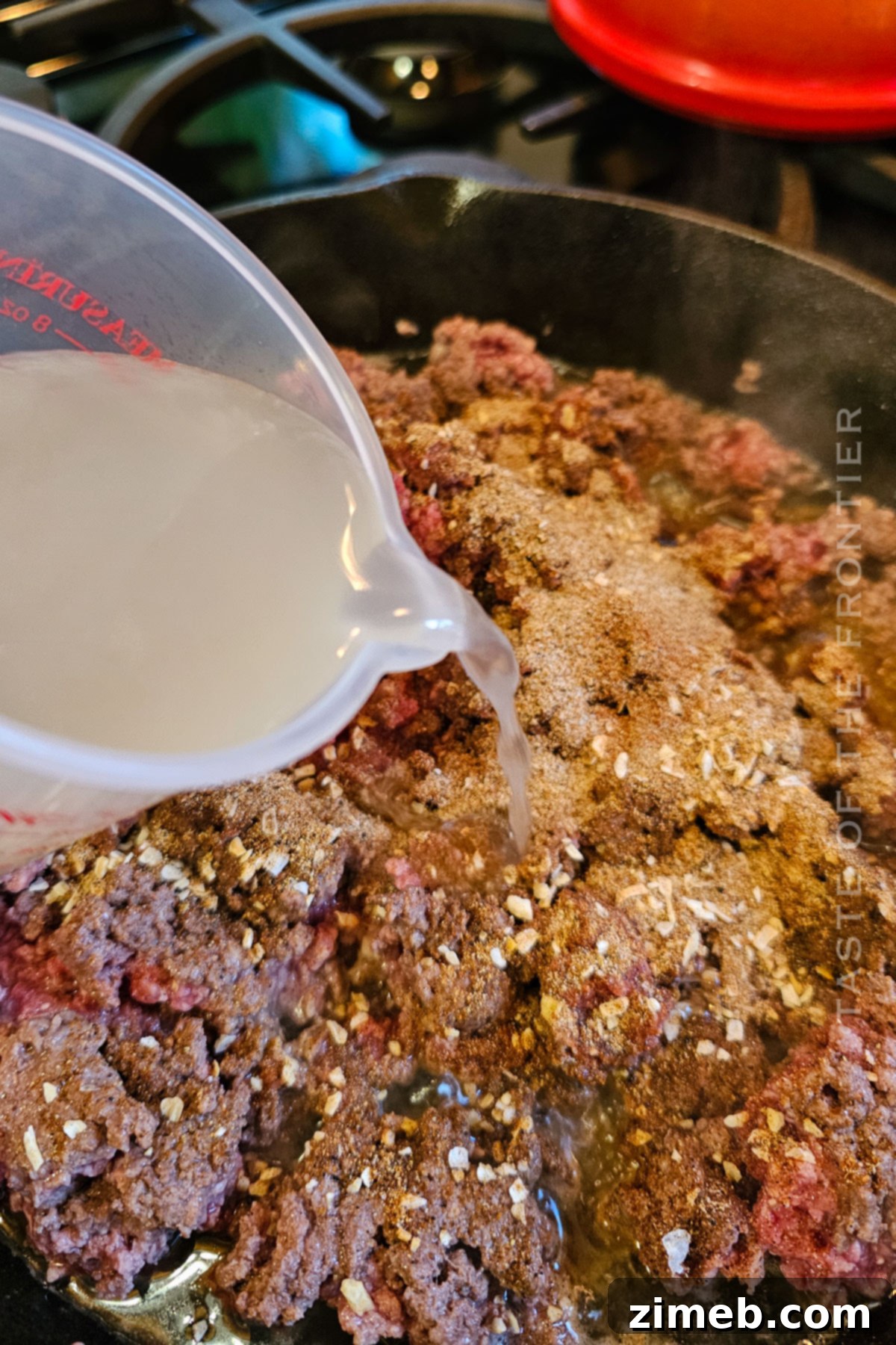Flavorful Taco Filling 8 Adding broth to the browning ground beef for the taco meat recipe.