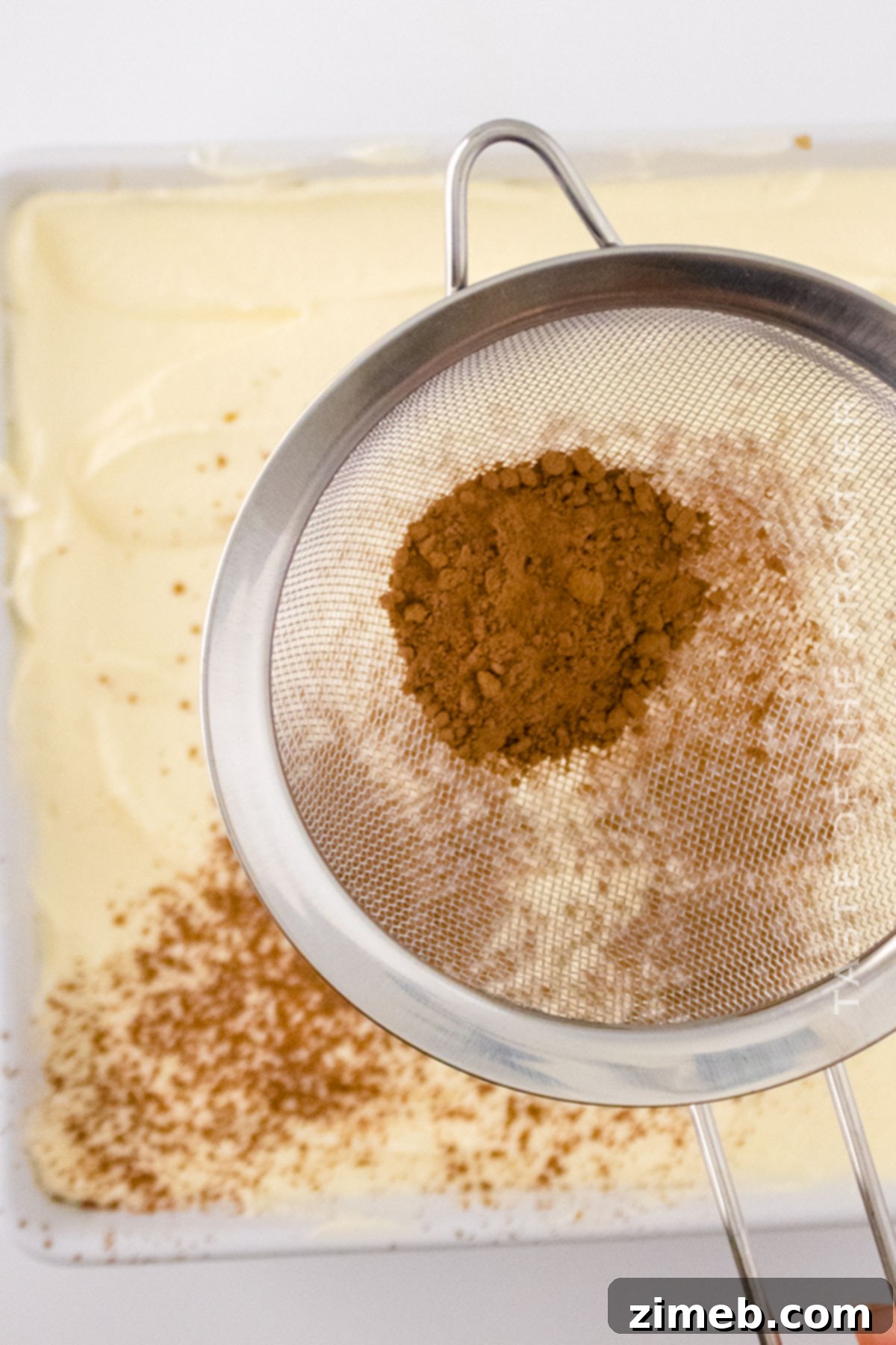 Spiced Biscoff Tiramisu 7 Finishing touch: dusting cocoa powder on Biscoff Tiramisu