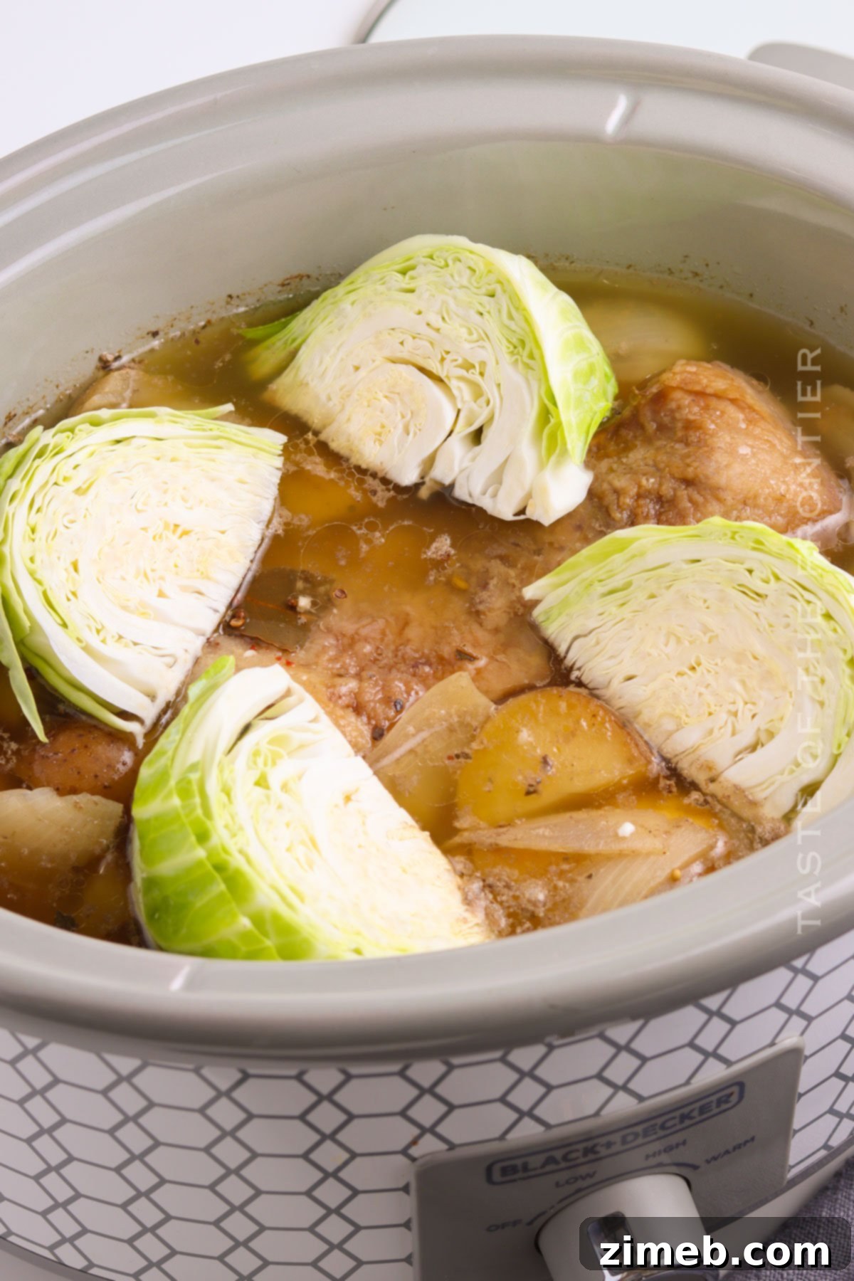 Adding cabbage to the Slow Cooker Corned Beef and Cabbage for the final cooking stage.