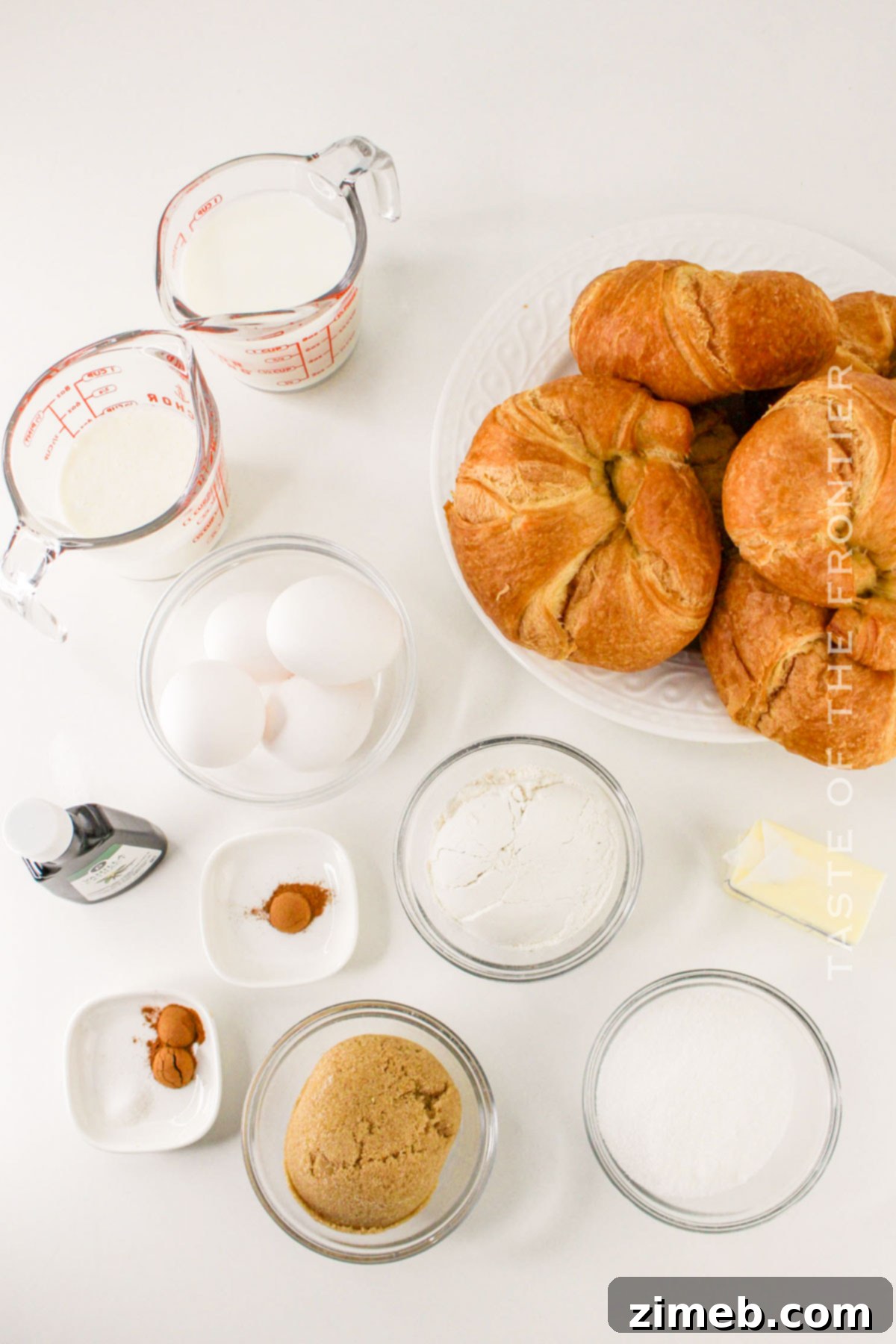 A selection of ingredients for Croissant French Toast casserole laid out on a table.