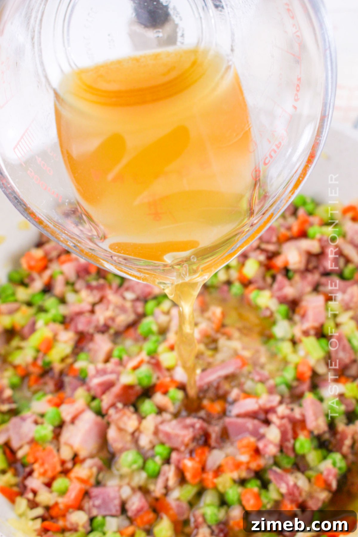 Adding broth to the ham pot pie filling