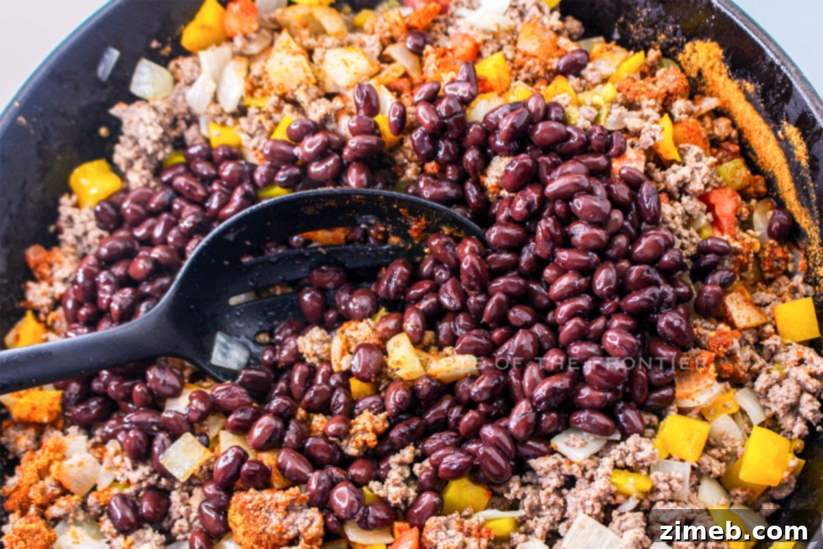 Fiesta Beef and Rice Skillet 6 Adding beans and seasonings to the beef and rice skillet