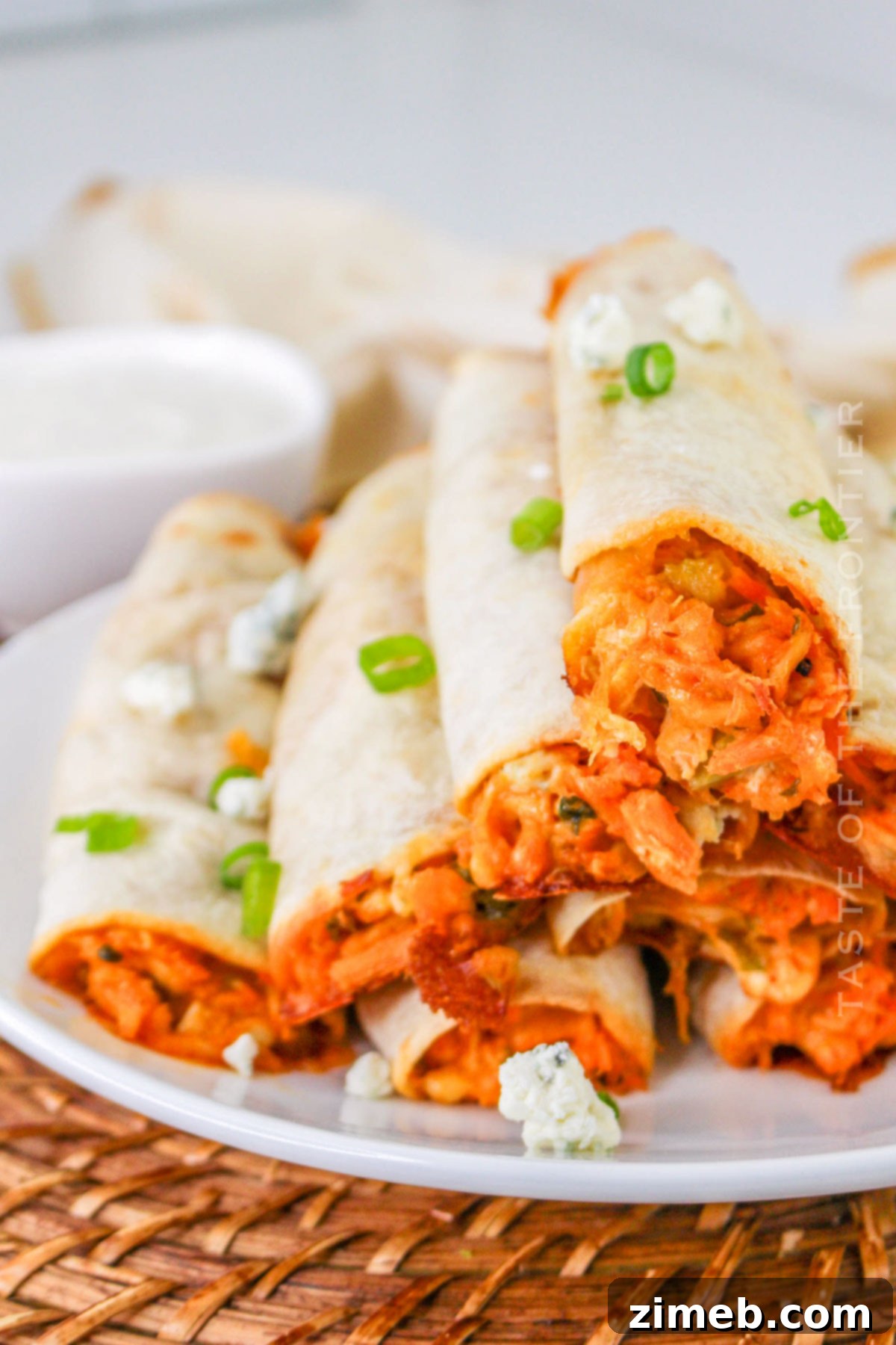 Crispy Buffalo Chicken Taquitos 15 A vibrant platter of Buffalo Chicken Taquitos with dipping sauces
