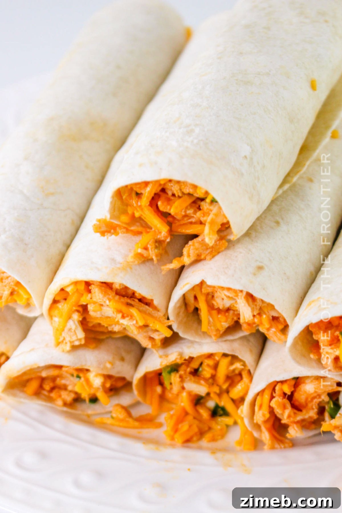 Crispy Buffalo Chicken Taquitos 8 Rolled taquitos on a baking sheet, ready for cooking