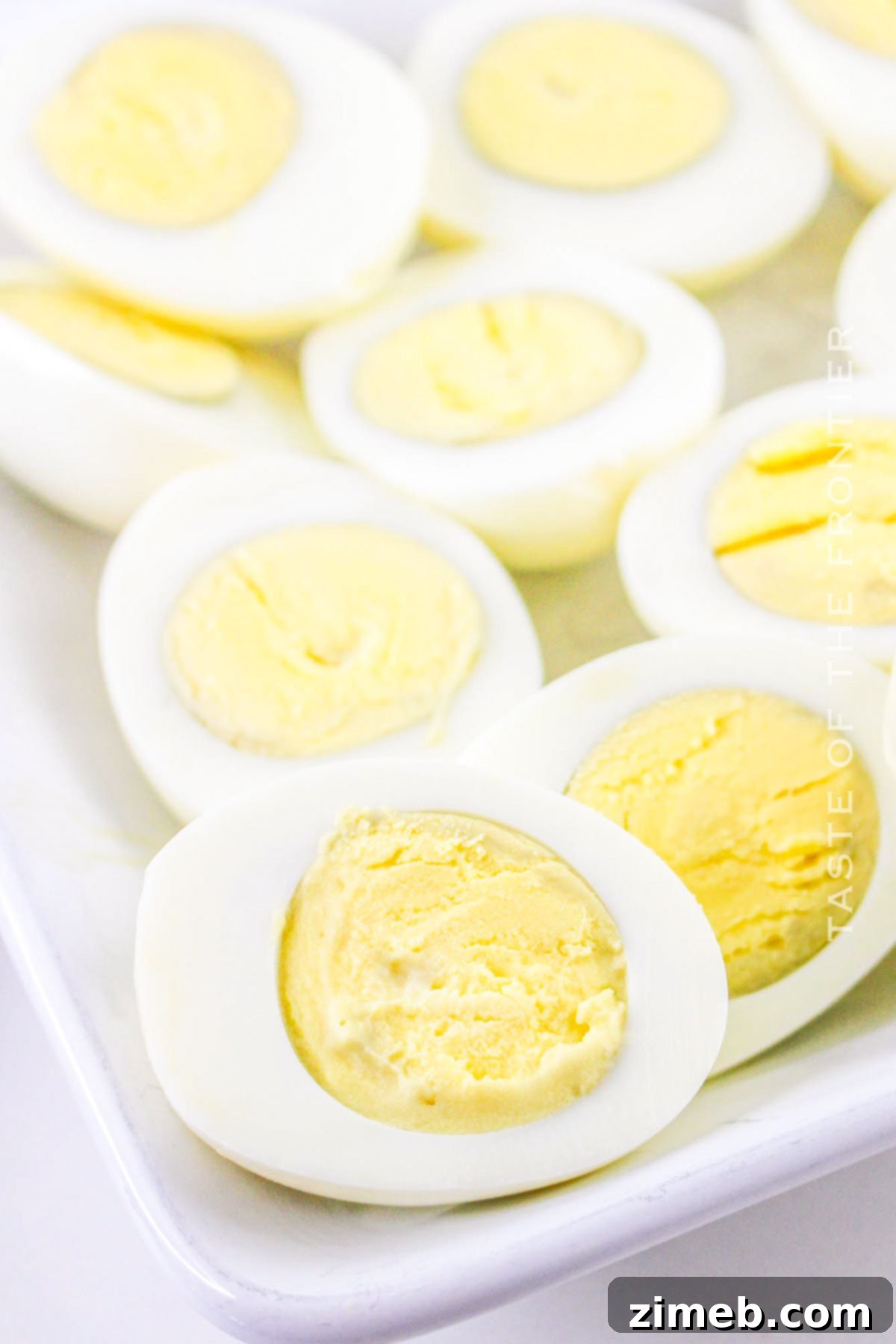 Zesty Jalapeño Deviled Eggs 5 Close-up of perfectly hard-boiled eggs, peeled and ready to be halved for deviled eggs, showcasing their smooth texture.