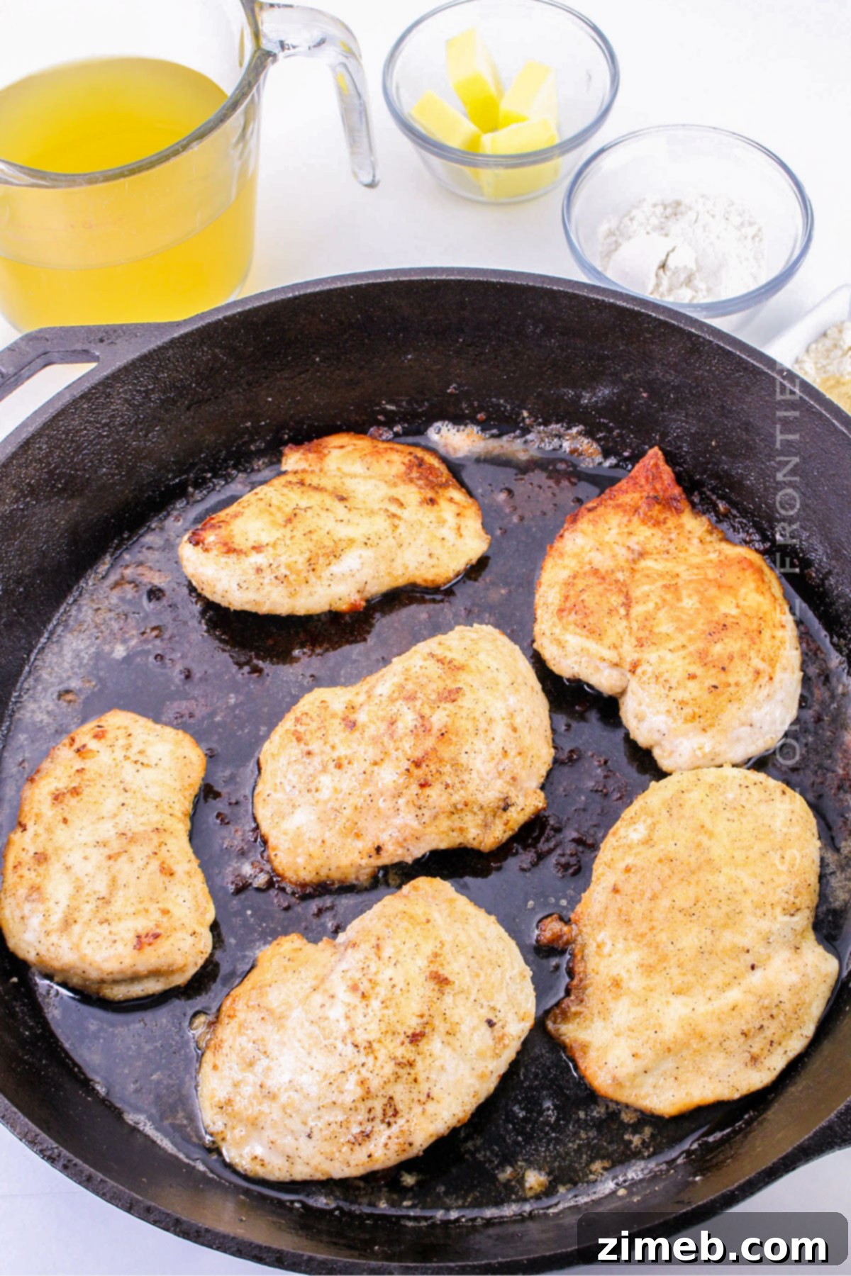 chicken in the skillet simmering in gravy