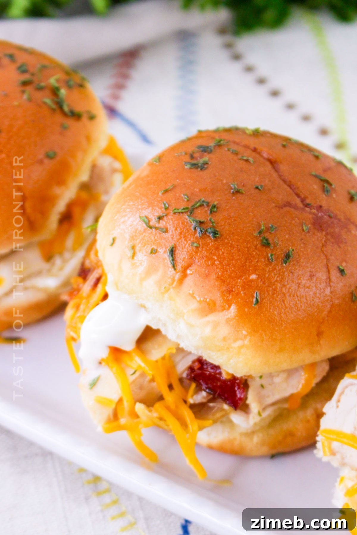 Ultimate Bacon Ranch Chicken Sliders 14 lunch sliders with bacon and cheese - a casual shot of a plate of Bacon Chicken Ranch Sliders, ready for a delicious lunch.