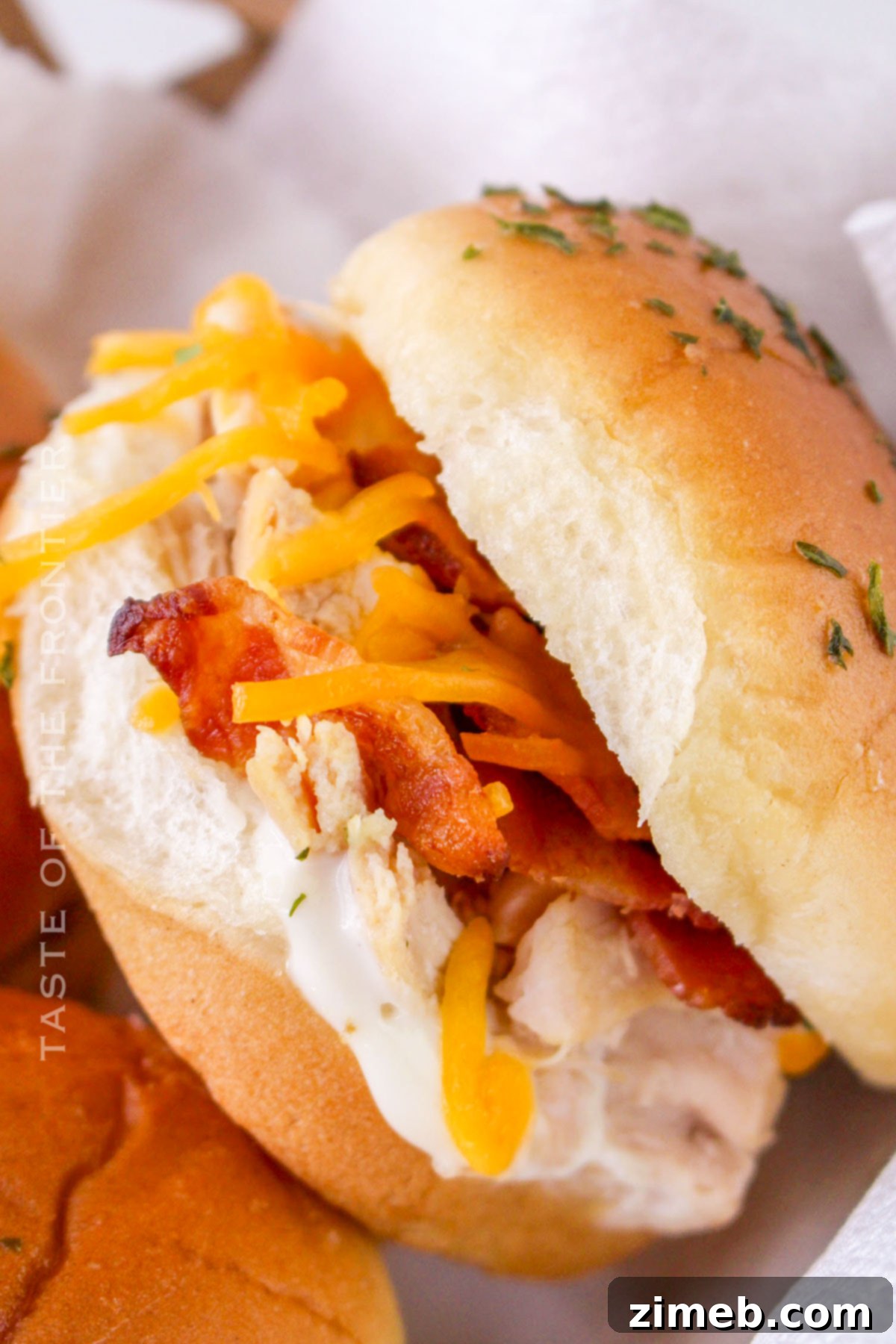 Ultimate Bacon Ranch Chicken Sliders 8 game day sliders - a tray of Bacon Chicken Ranch Sliders with a football in the background, perfect for a game day party.